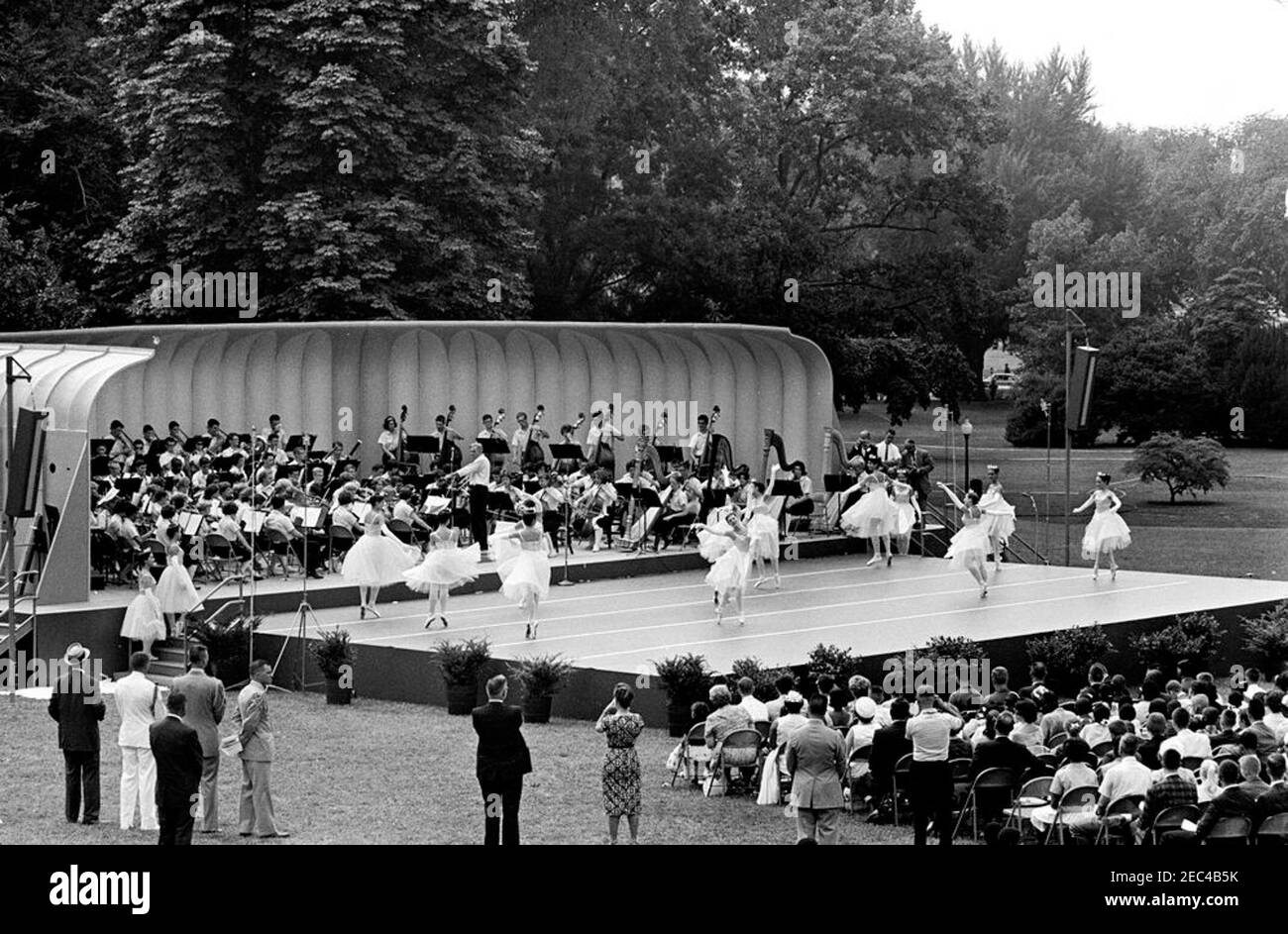 First Lady Jacqueline Kennedyu0027s (JBK) programma musicale per la gioventù, 10:35. Ballerini di balletto e membri della National High School Symphony Orchestra (entrambi provenienti dal campo di musica nazionale di Interlochen, Michigan) si esibiscono sul prato meridionale durante la quarta serie di programmi musicali per giovani della First Lady Jacqueline Kennedyu2019. Il presidente del National Music Camp, Dr. Joseph E. Maddy (centro a sinistra, in tribuna), dirige l'orchestra. White House, Washington, D.C. Foto Stock