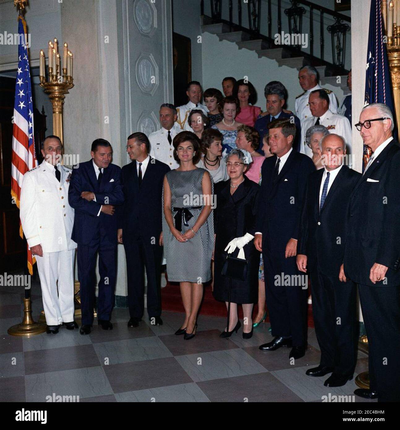 Accoglienza militare alla Casa Bianca, alle 18:00. Il presidente John F. Kennedy, la First Lady Jacqueline Kennedy, e altri frequentano un ricevimento militare alla Casa Bianca. Prima fila (L-R): Presidente dei Capi congiunti del personale, Generale Lyman L. Lemnitzer; Segretario dell'Esercito, Elvis J. Stahr, Jr.; Segretario della Difesa, Robert S. McNamara; Sig.ra Kennedy; Katherine Lemnitzer, moglie del Generale Lemnitzer; Presidente Kennedy; Segretario dell'Aeronautica, Eugene M. Zuckert; Segretario della Marina, Fred Korth. Anche nella foto: Generale Maxwell D. Taylor e sua moglie Lydia Taylor; militare Aide al presidente, GE Foto Stock
