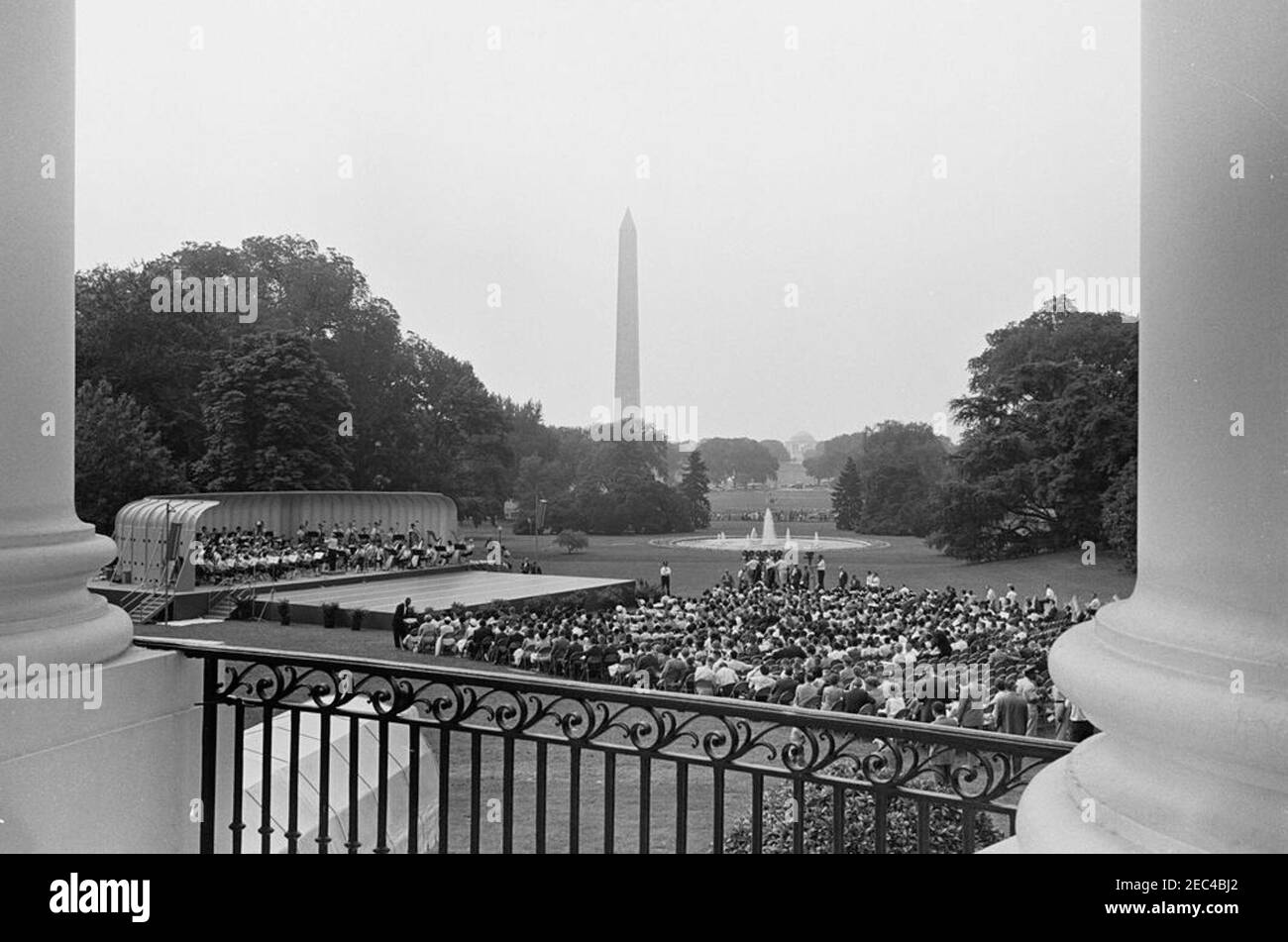 First Lady Jacqueline Kennedyu0027s (JBK) programma musicale per la gioventù, 10:35. Ampia vista del Prato Sud durante la quarta in prima Lady Jacqueline Kennedyu2019s serie di programmi musicali per la Gioventù, come si vede dal portico Sud. I membri della National High School Symphony Orchestra del National Music Camp di Interlochen, Michigan, si esibiscono a sinistra in background; il presidente del National Music Camp, Dr. Joseph E. Maddy (in tribuna), dirige l'orchestra. Il Washington Monument e il Jefferson Memorial sono visibili in lontananza. White House, Washington, D.C. Foto Stock