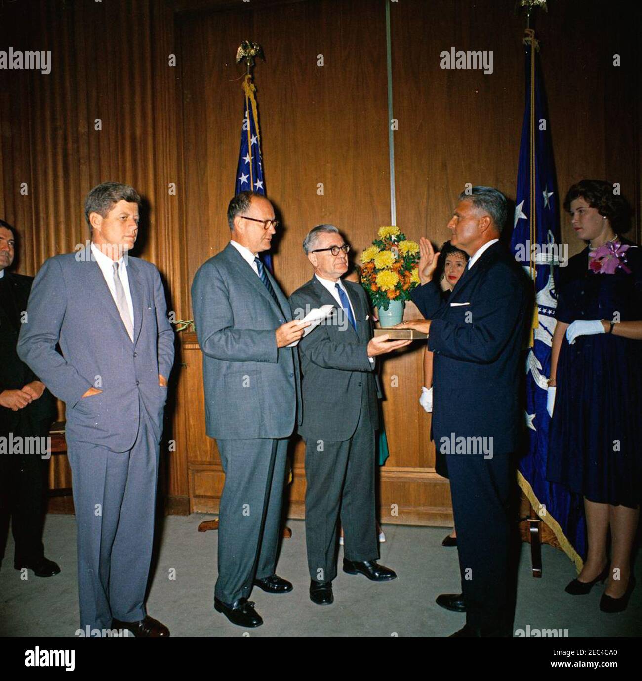 Cerimonia di giuramento, James J. Rowley, Direttore del Servizio Segreto, 10:37. I partecipanti e gli ospiti partecipano alla cerimonia di giuramento per il nuovo direttore del servizio segreto James J. Rowley presso il Dipartimento del Tesoro di Washington, D.C. (L-R) il direttore Roweyu2019s fratello Reverendo Francis P. Rowley (parzialmente fuori quadro); il presidente John F. Kennedy; il segretario del Tesoro C. Douglas Dillon; l'impiegato non identificato (holding Bible); Regista Raweyu2019s moglie Mabel Rita Cluen Rowley; regista Rowley; regista Rawleyu2019s figlia Claudia Rowley. Foto Stock