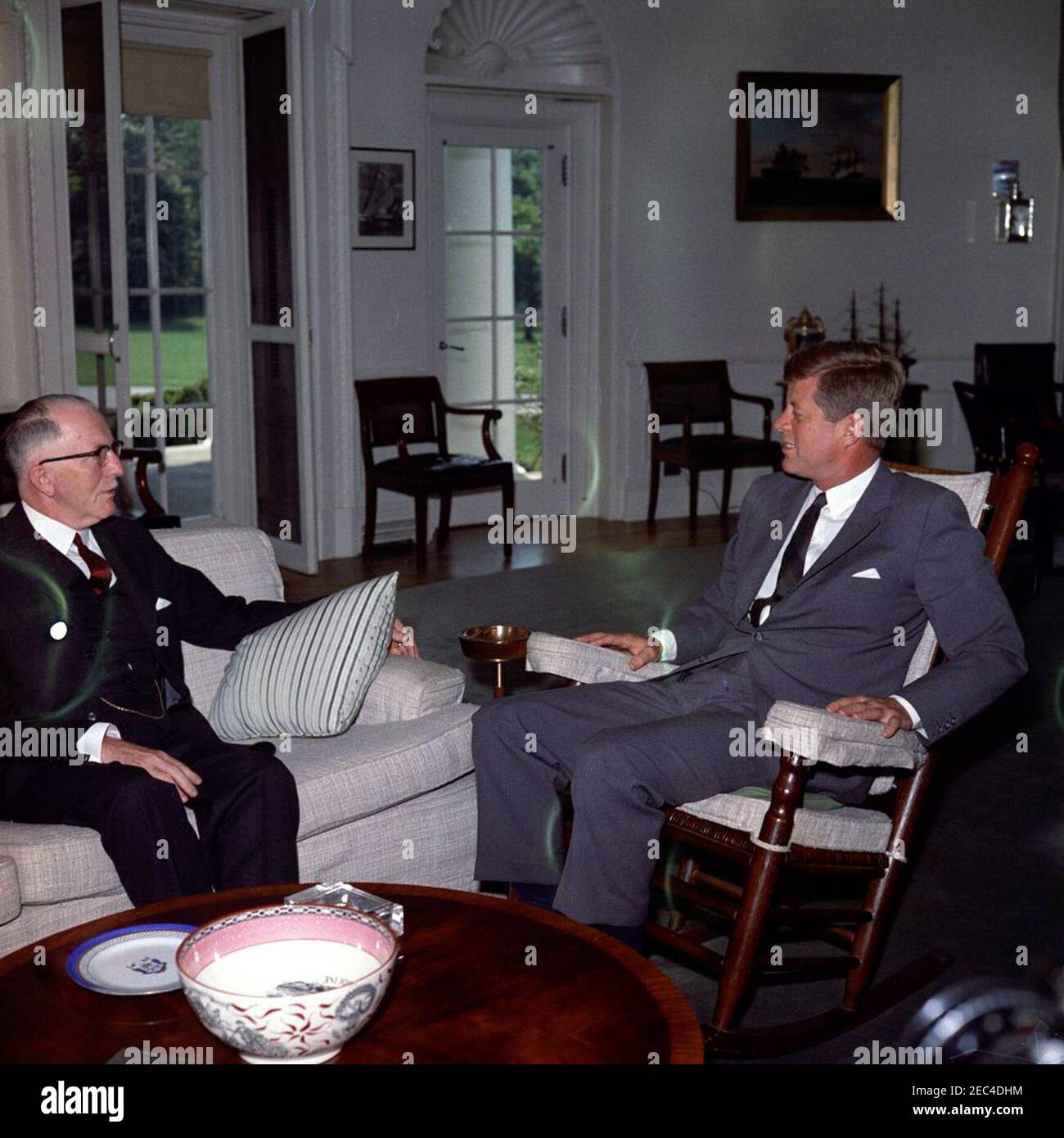 Incontro con H. Ladd Plumley, presidente della Camera di Commercio degli Stati Uniti, alle 10:37. Il presidente John F. Kennedy (in sedia a dondolo) incontra il presidente della Camera di Commercio degli Stati Uniti, H. Ladd Plumley. Ufficio ovale, Casa Bianca, Washington, D.C. [danno da originale a negativo] Foto Stock