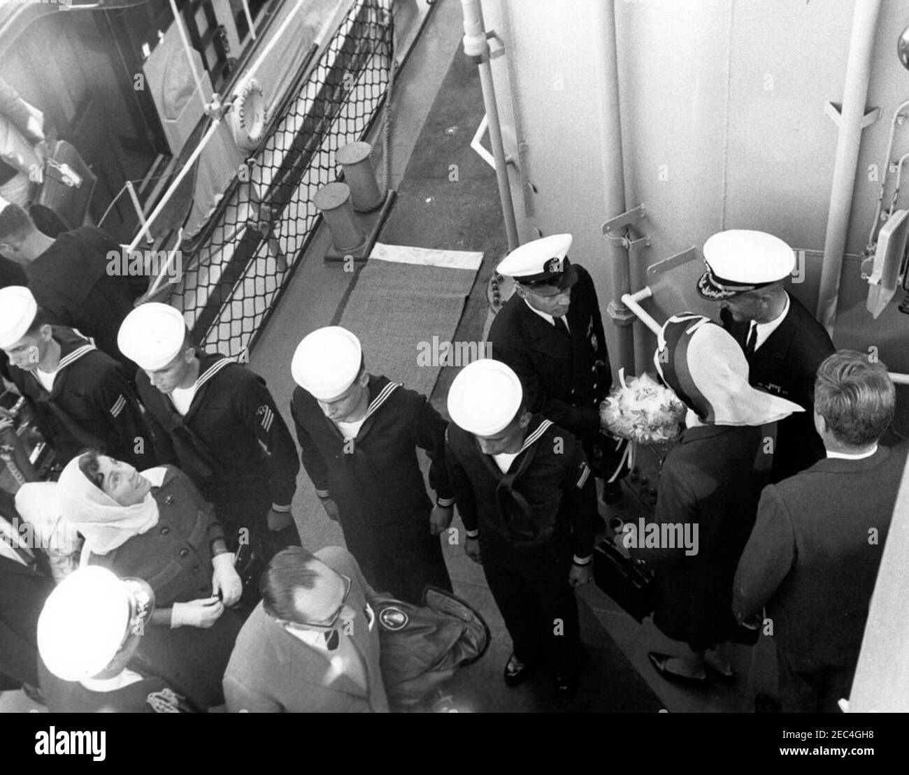 Il presidente Kennedy si accuda alla prima gara di Coppa Americau0027s. Il presidente John F. Kennedy e la First Lady Jacqueline Kennedy (entrambi a destra) arrivano a bordo della USS Joseph P. Kennedy, Jr., per assistere alla prima gara della Coppa Americau0027s del 1962. Anche nella foto: Janet Lee Auchincloss; Naval Aide al Presidente, Capitano Tazewell Shepard; Ambasciatore di Gran Bretagna, Sir David Ormsby-Gore. I marinai della marina degli Stati Uniti stanno all'attenzione. Newport, Rhode Island. Foto Stock