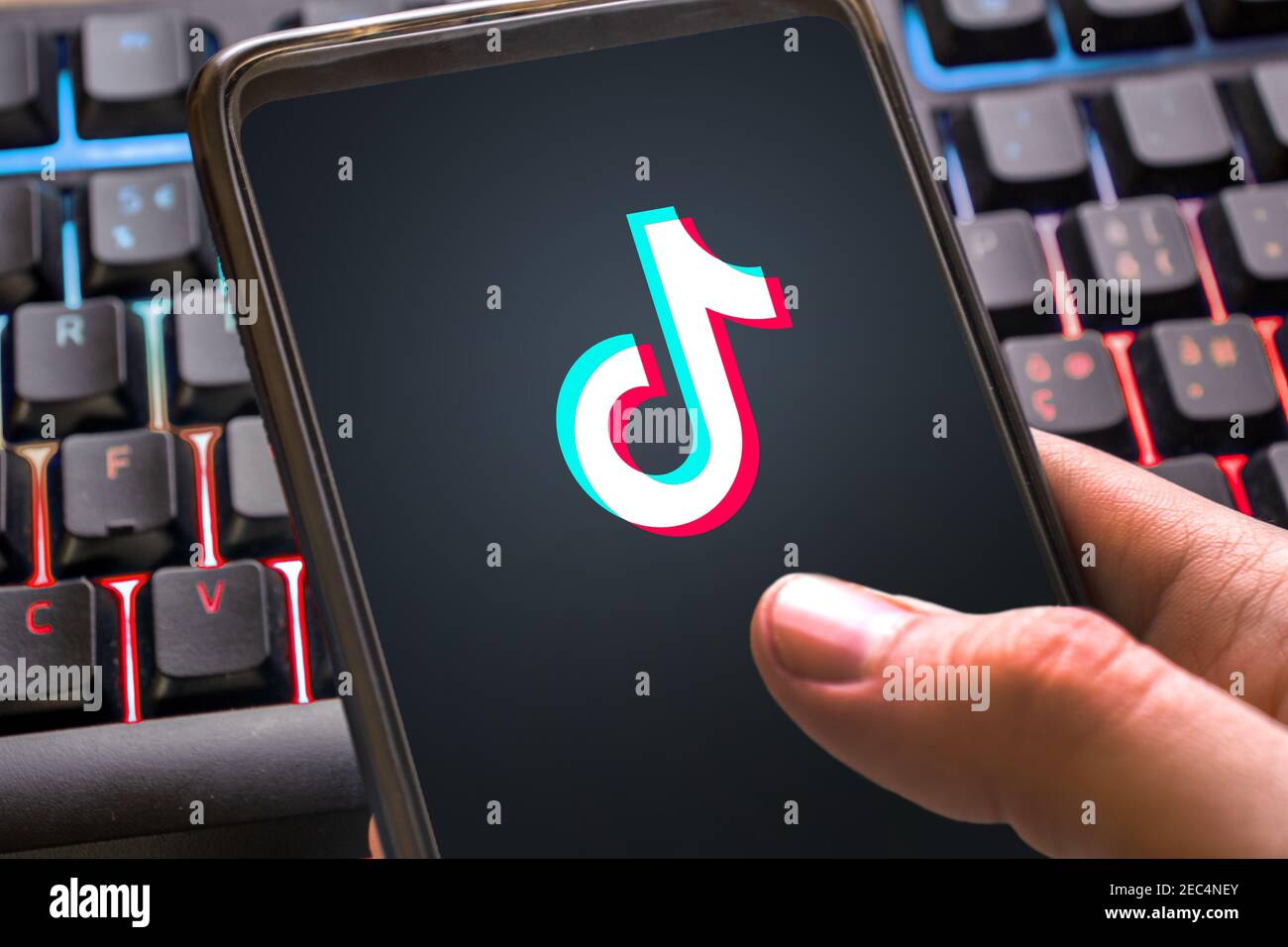 Logo Tiktok con sfondo colorato sullo smartphone. Social network per video per giovani vicino Foto Stock