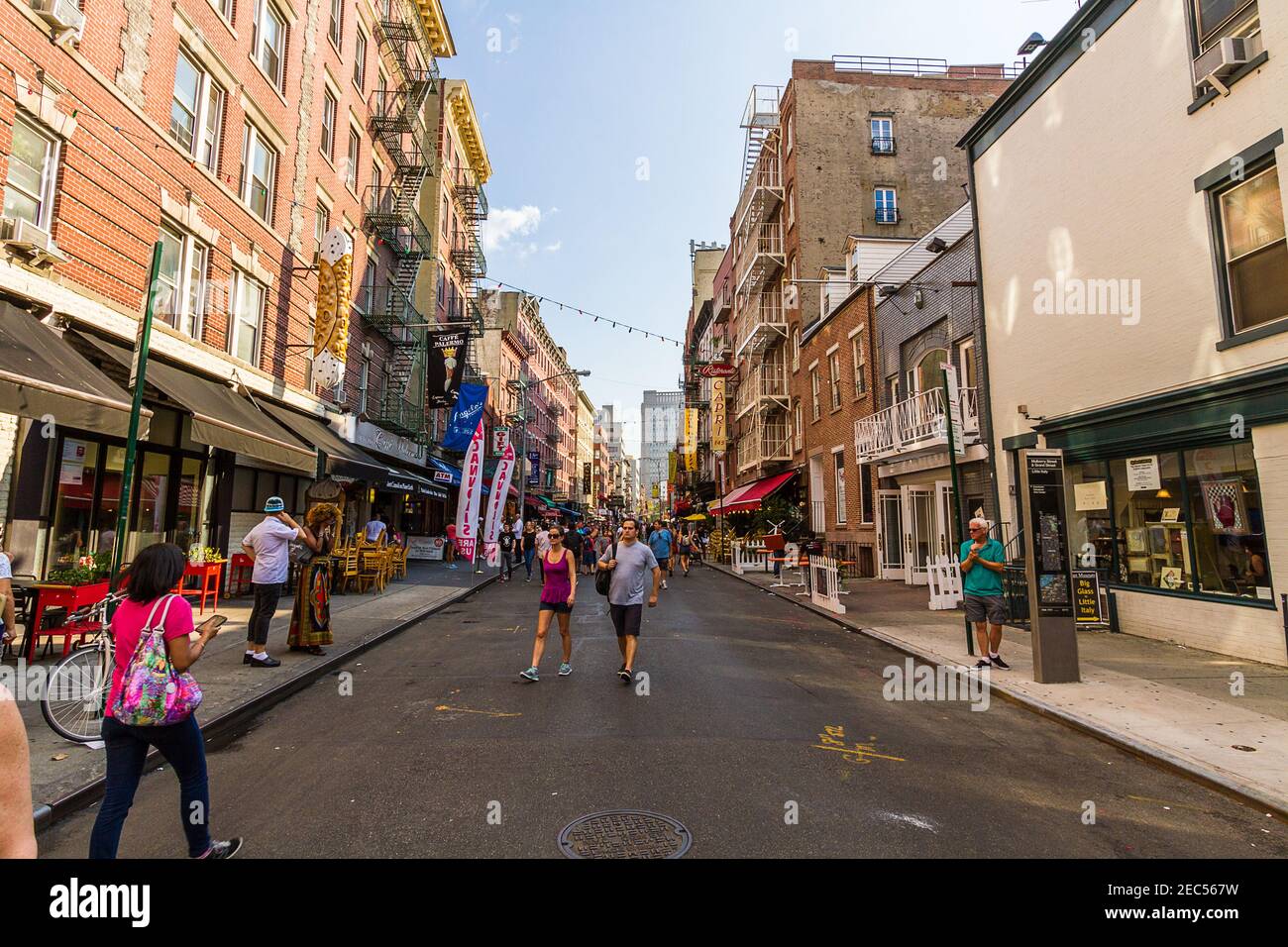 Persone che camminano su Mulberry Street in Little Italy dal Ristoranti italiani e negozi di articoli da regalo Foto Stock