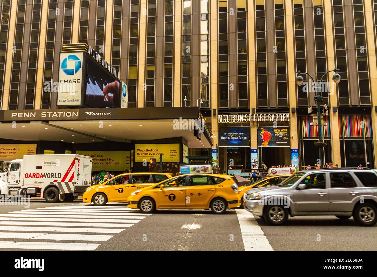Penn Station e il Madison Square Garden, vista dall'ingresso della strada principale con persone, auto e taxi Foto Stock