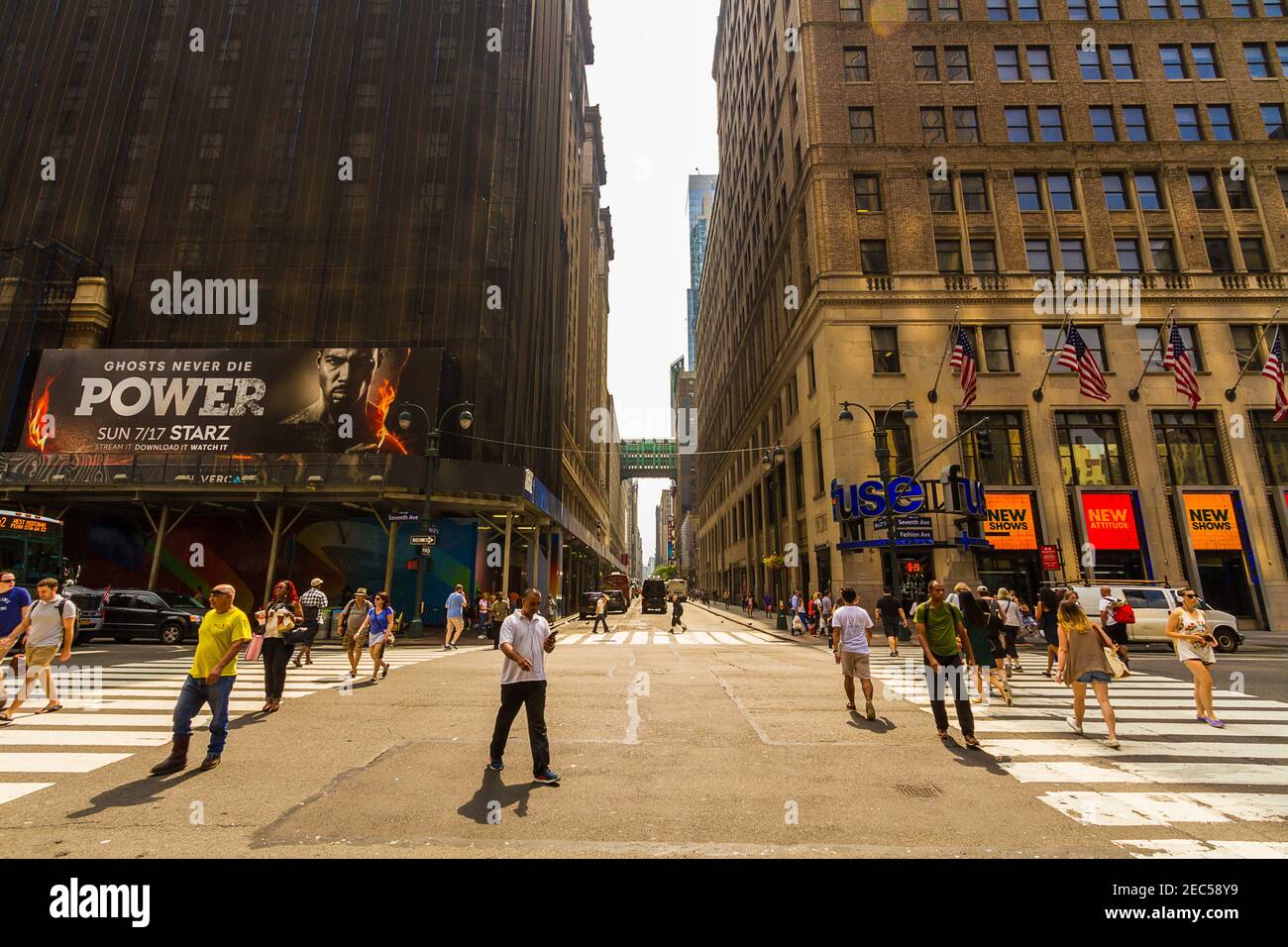 7th Avenue Street a Manhattan, New York City con persone che camminano e attraversano la strada e con un cartello pubblicitario Foto Stock