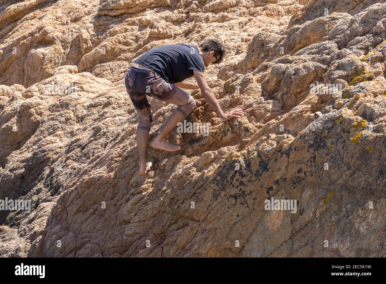 Giovane uomo che arrampica parete rocciosa senza alcuna assicurazione, roccia-scalata sport estremo, copia spazio, Spagna Foto Stock