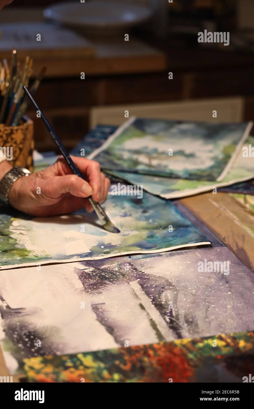 Artista che lavora a casa durante Covid 19 virus lockdown.House Bound artista, terapeuticamente dipingere una pittura picture-spazzolando vernice e la creazione di una composizione. Foto Stock