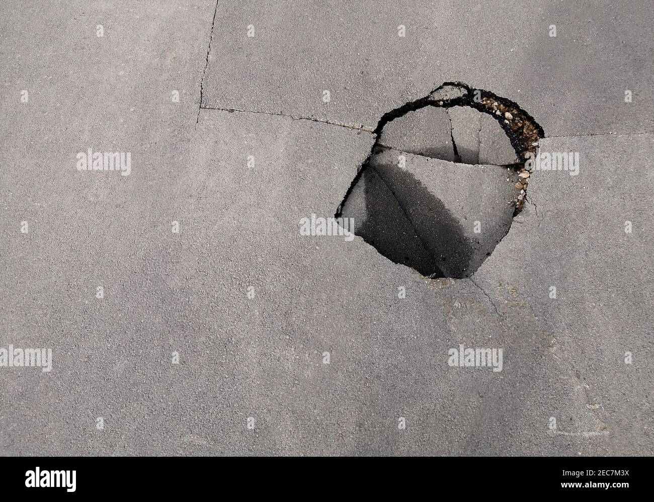 Un buco nella strada. Buca nell'asfalto. Strada rotta. Strada asfaltata danneggiata Foto Stock