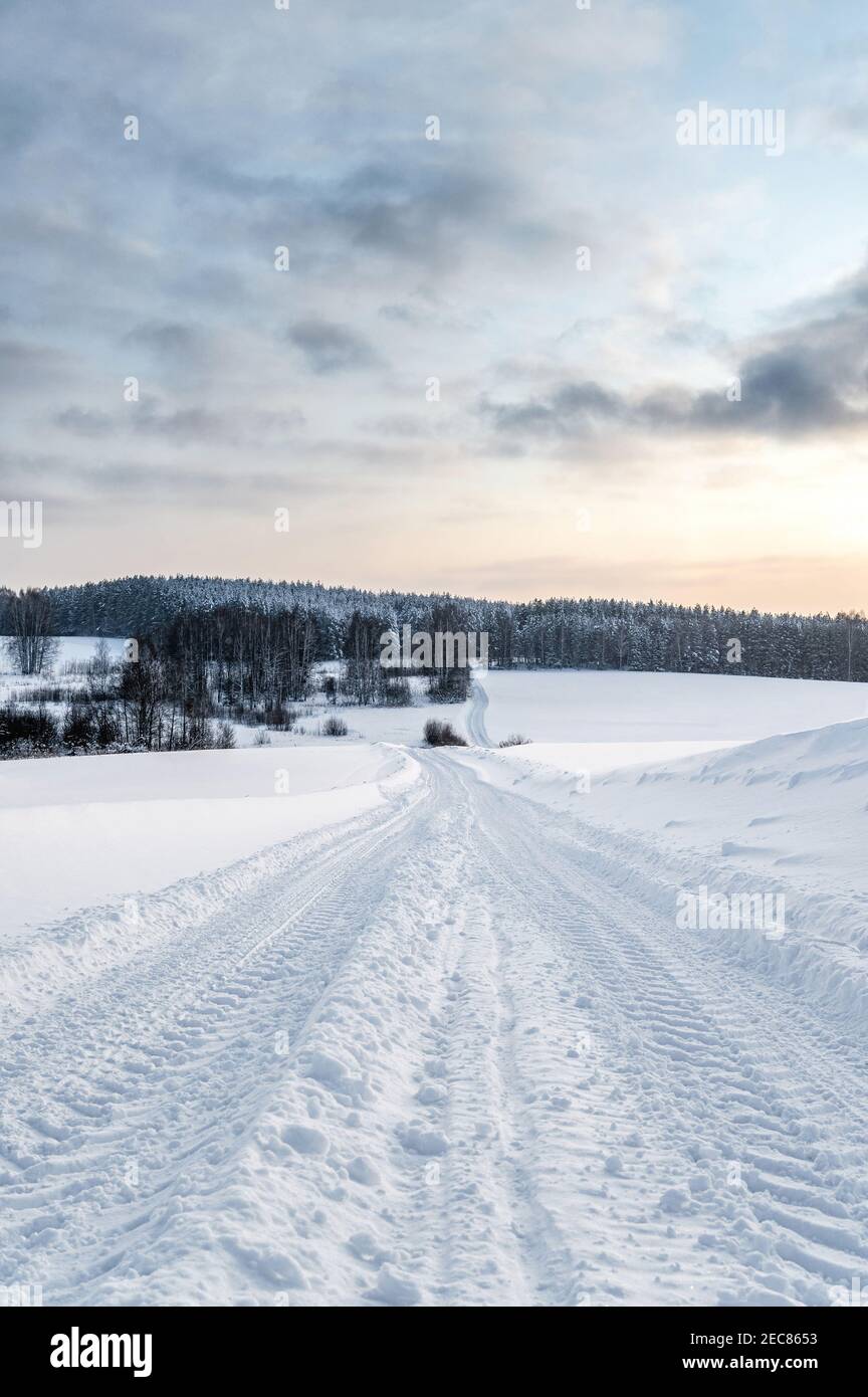 Paesaggio invernale, strada dopo la nevicata, nuvole nel cielo, natura settentrionale Foto Stock