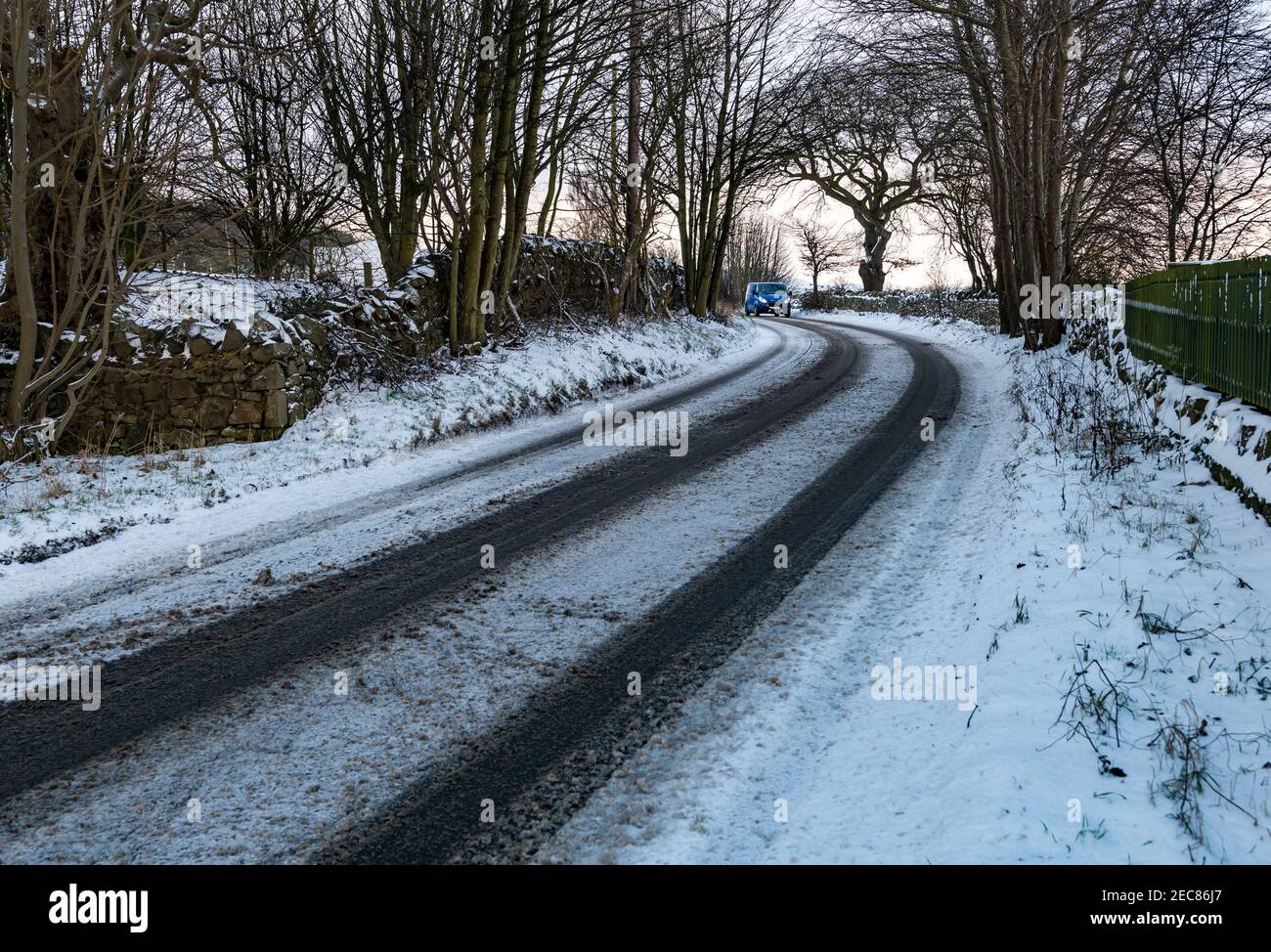 Van che guida curva rotonda su neve coperta strada di campagna in inverno, East Lothian, Scozia, Regno Unito Foto Stock