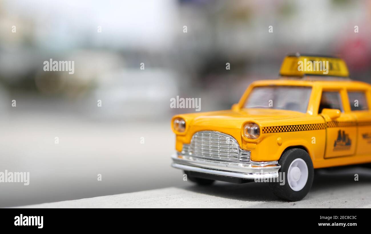 Mini taxi giallo vacante vicino, angolo di Harmon, Las Vegas, USA. Modello di auto retrò di piccole dimensioni su sfondo sfocato. Piccolo giocattolo per auto iconico come simbolo o Foto Stock