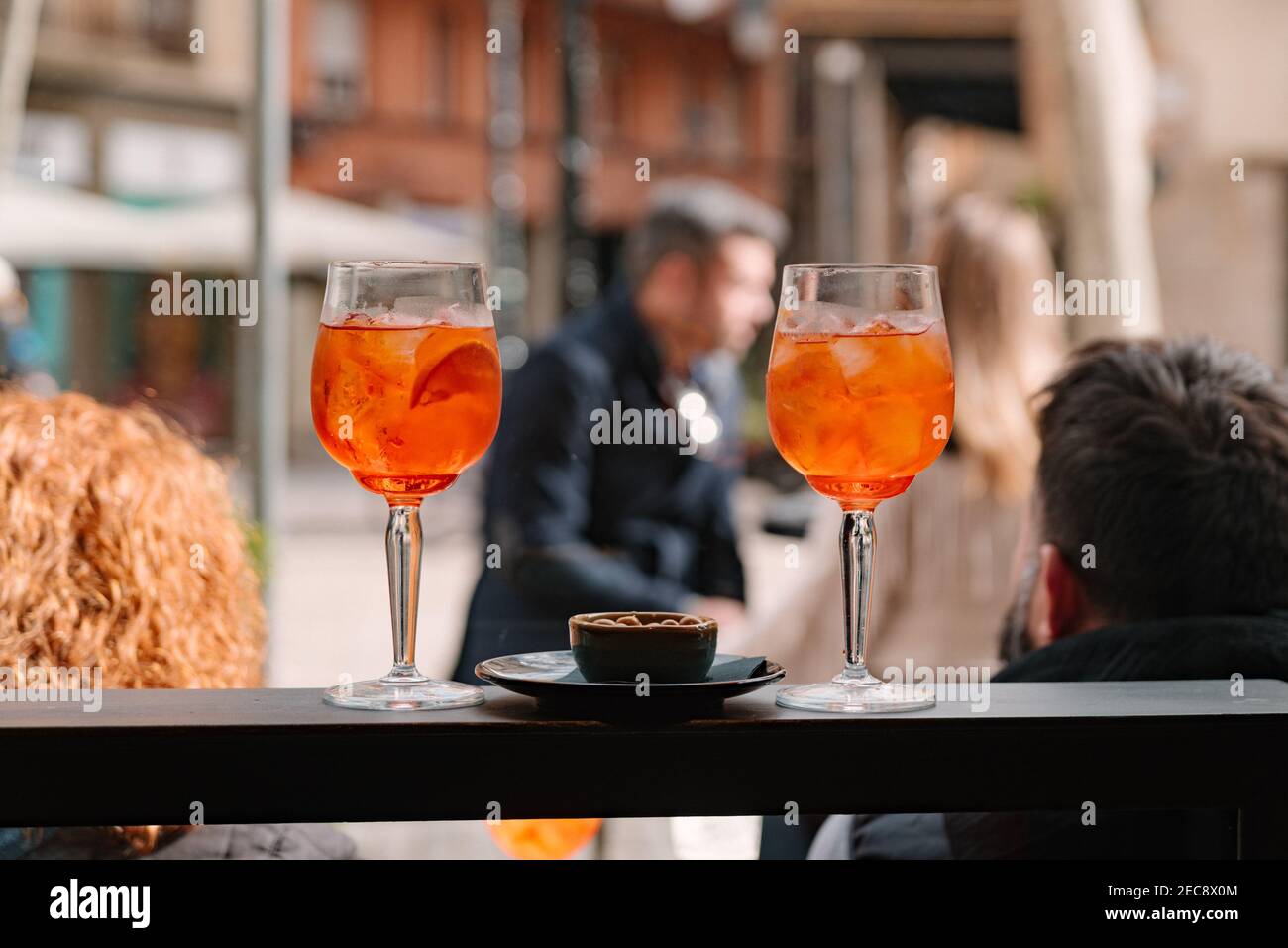 coppia di due bicchieri di aperol spritz al bar con happy hour italiano tradizionale con olive. persone all'aperto nella terrazza del bar Foto Stock