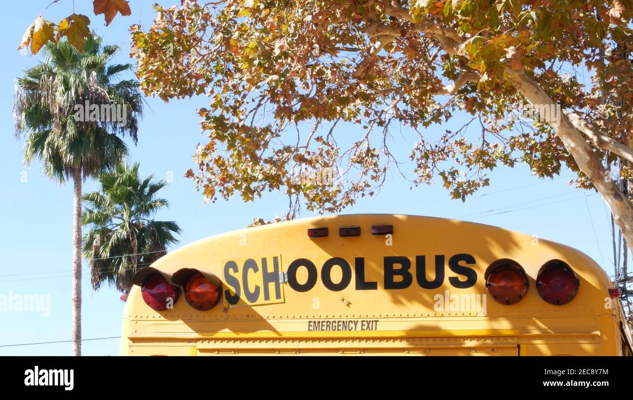 Autobus scolastico giallo iconico a Los Angeles, California USA. Veicolo classico per studenti vista posteriore. Luci di arresto del veicolo per la sicurezza del trasporto di bambini Foto Stock