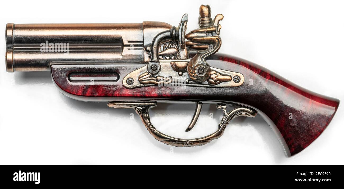 Primo piano di una vecchia pistola dorata con una ciliegia manico in legno Foto Stock