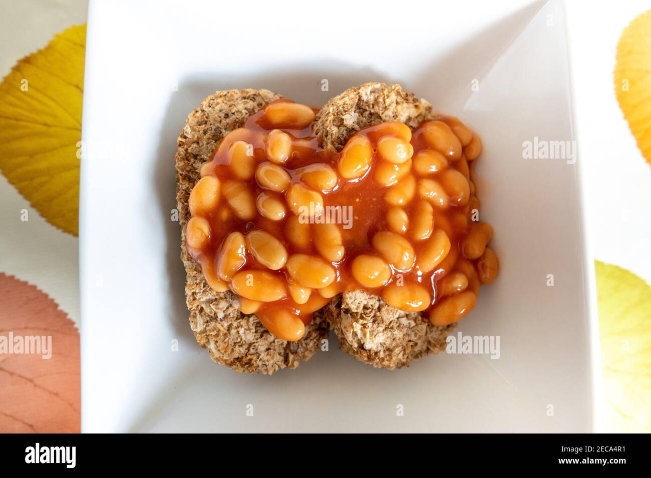 Weetabix con fagioli cotti sopra in un piatto bianco, cibo insolito Fad. Foto Stock