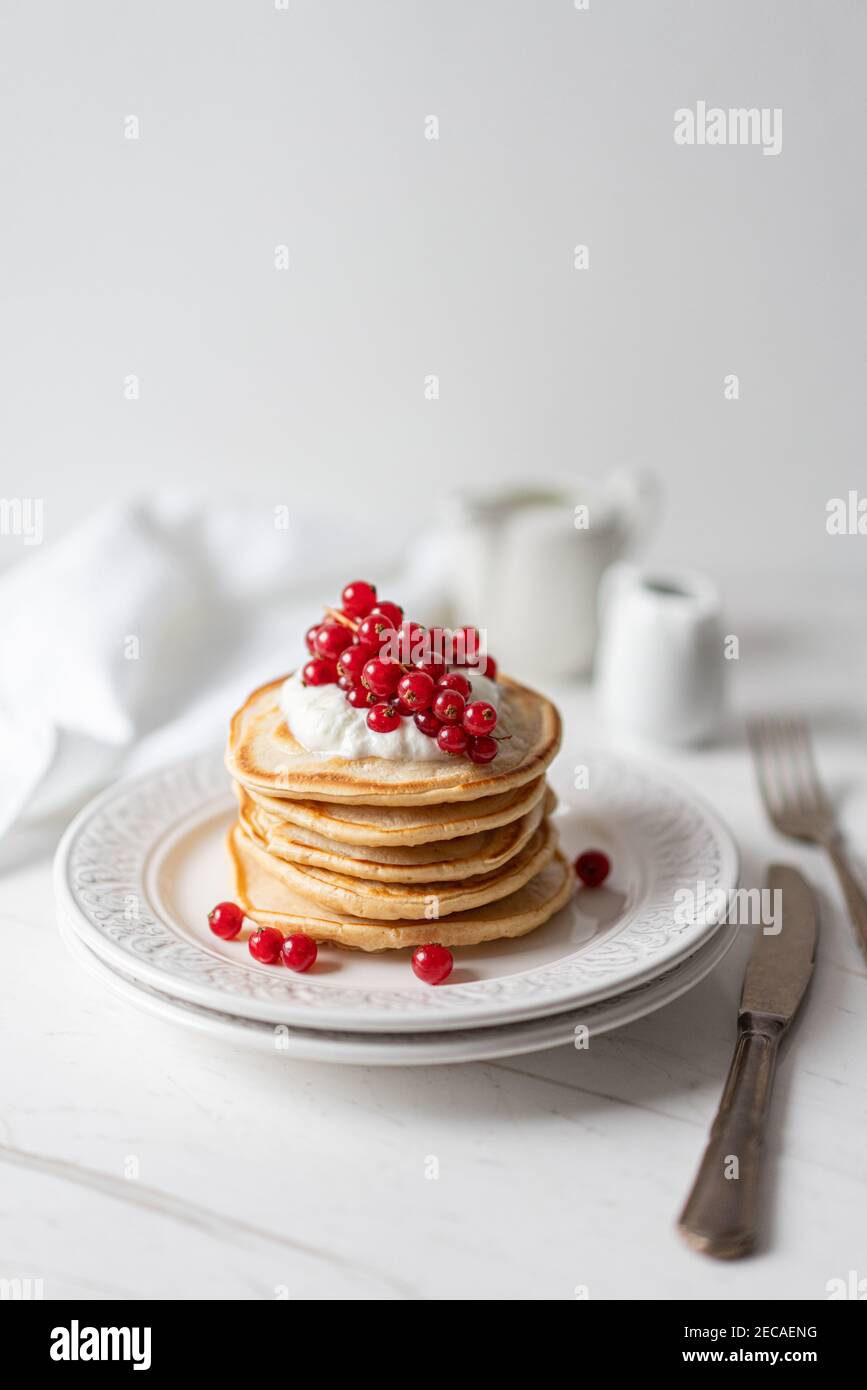 Frittelle di arachidi americane con mirtilli rossi, sciroppo d'acero e yogurt, Morning Flat Lay Foto Stock