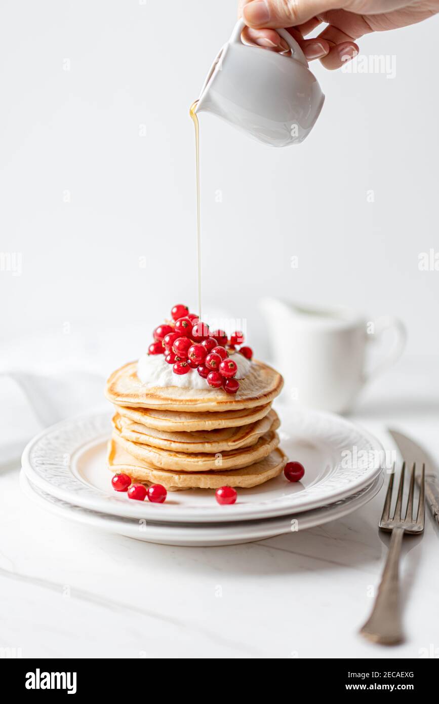 Frittelle di arachidi americane con mirtilli rossi, sciroppo d'acero e yogurt, Morning Flat Lay Foto Stock