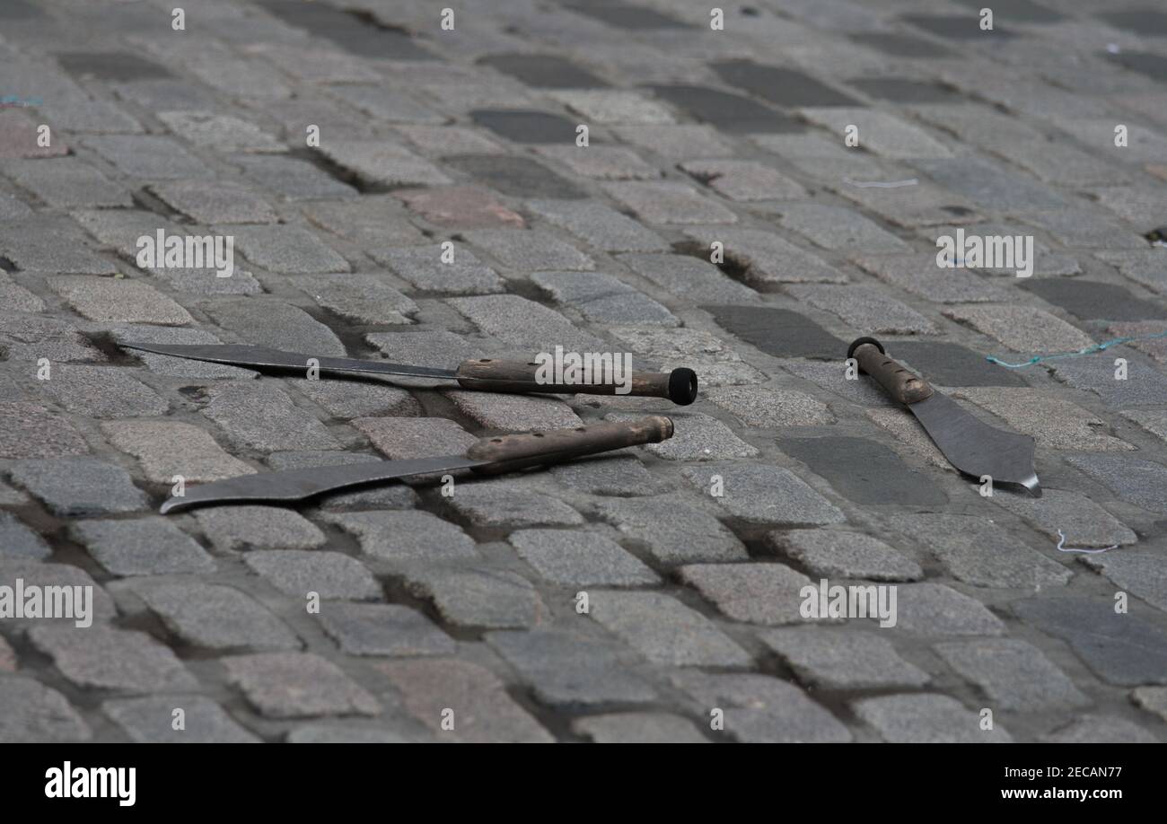 Lanciare o giocolare coltelli su una strada acciottolata. Concetto anche per la criminalità dei coltelli. Foto Stock