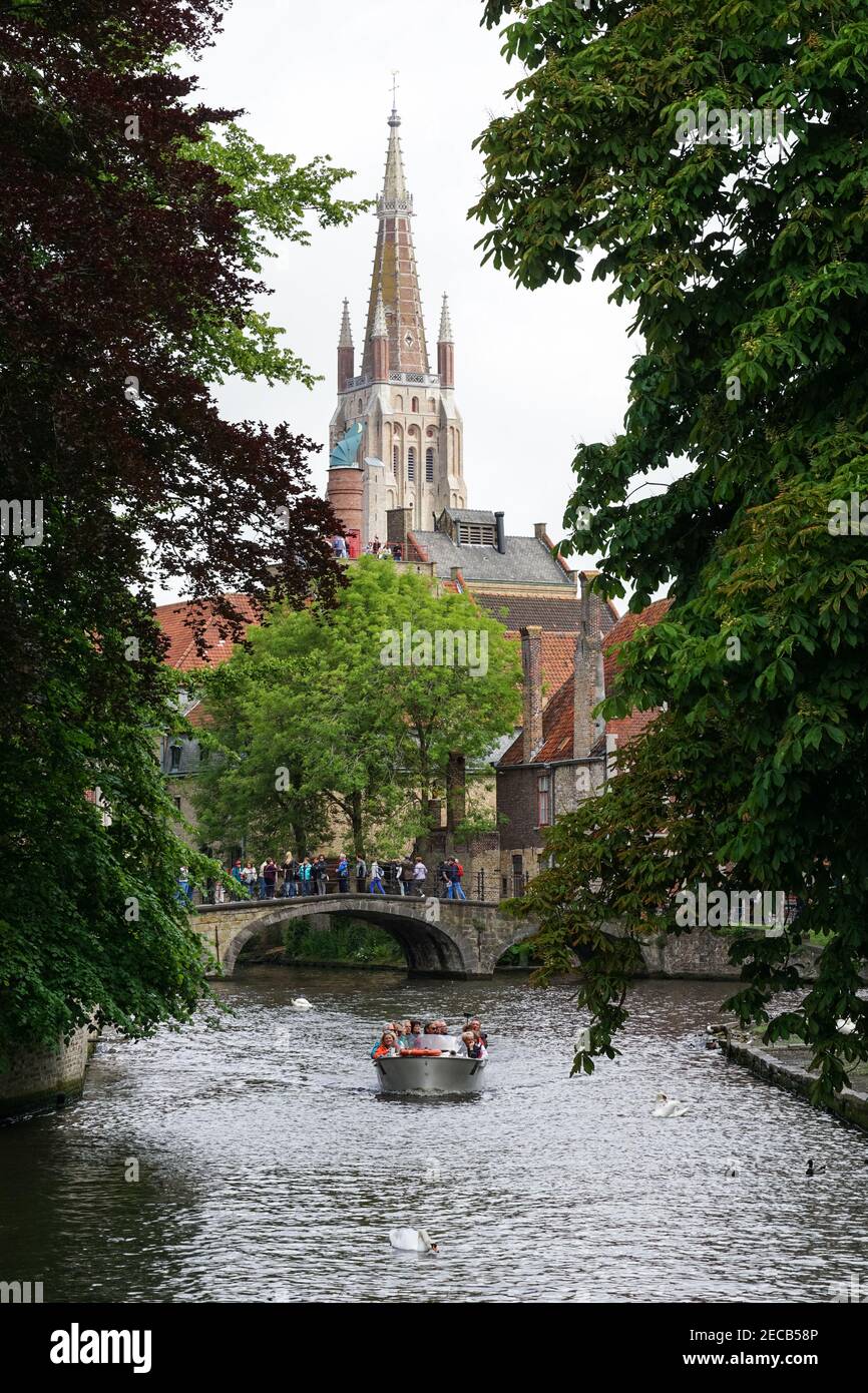 Turisti su un ponte sul canale Bakkersrei con la torre della Chiesa di nostra Signora sullo sfondo, Bruges, Belgio Foto Stock