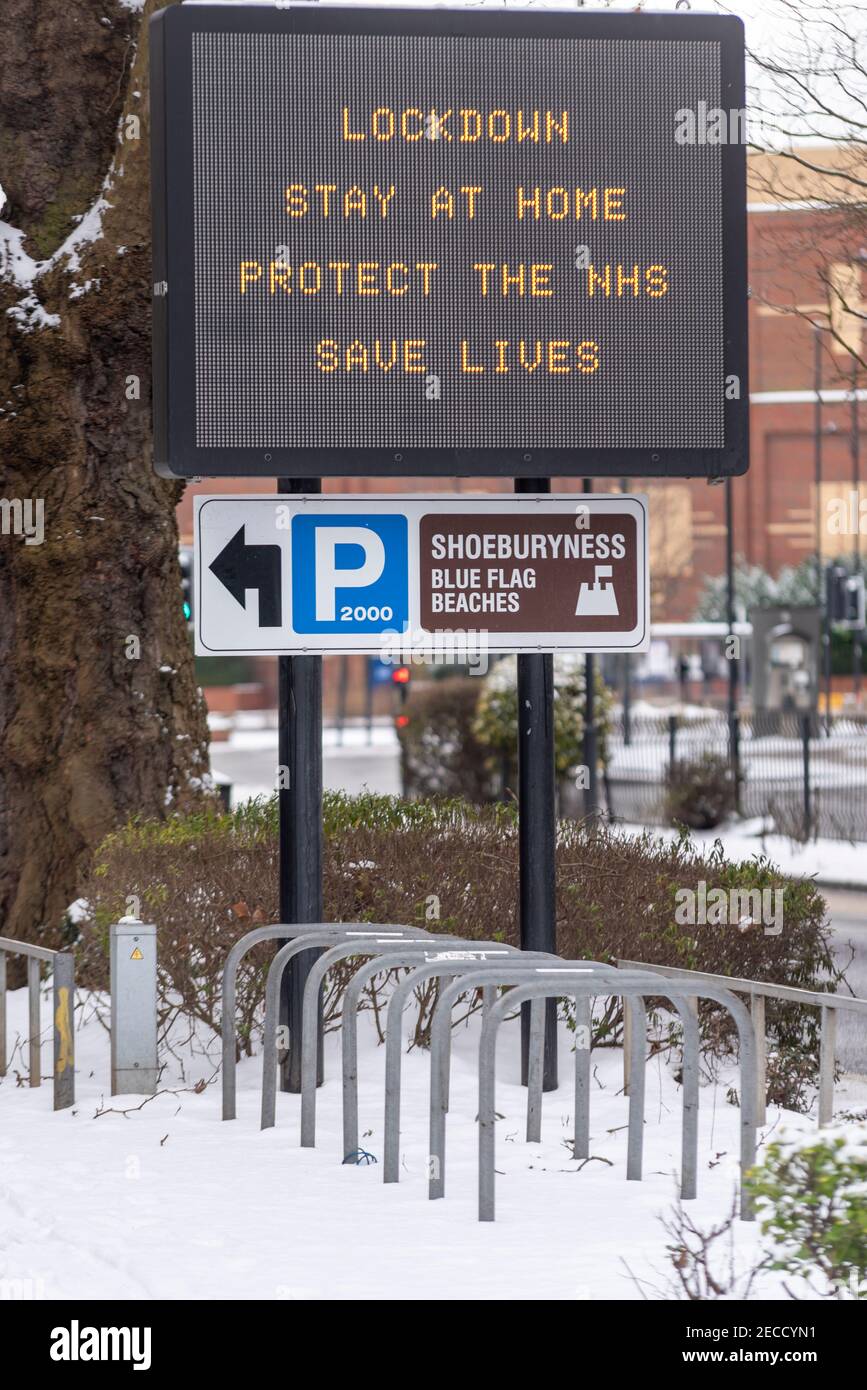 COVID 19 lockdown governo linee guida segno matrice sulla A127 Victoria Avenue a Southend sul mare, Essex, Regno Unito, con neve da Storm Darcy Foto Stock