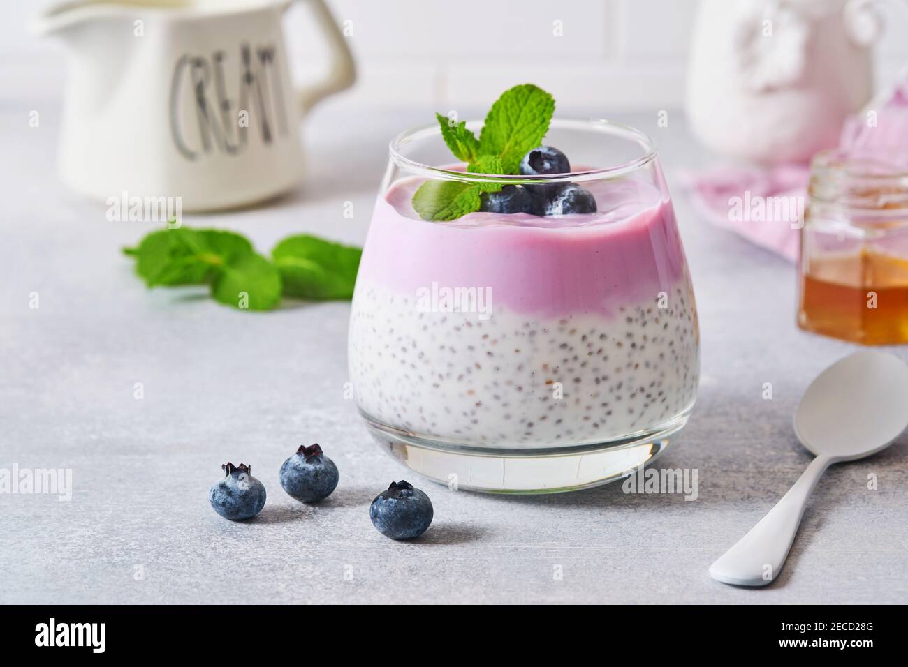 Budino di semi di Chia con yogurt al mirtillo e frutti di bosco freschi in vetro preparati per una sana colazione. Messa a fuoco selettiva. Foto Stock