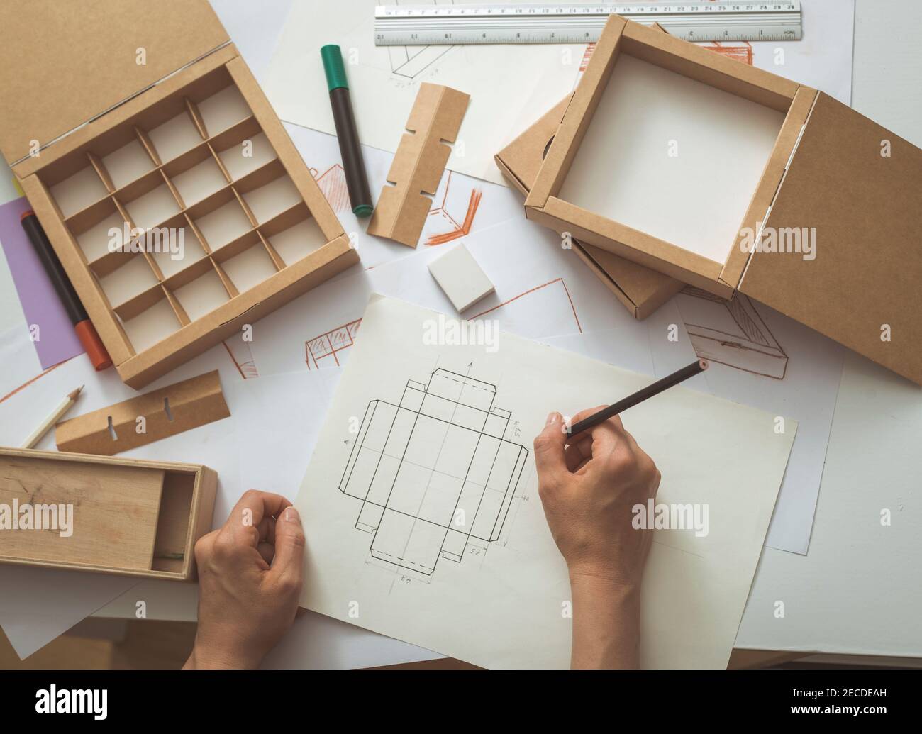 Designer disegna un mockup per la creazione di una scatola di cartone. Sviluppo  di packaging design sketch Foto stock - Alamy