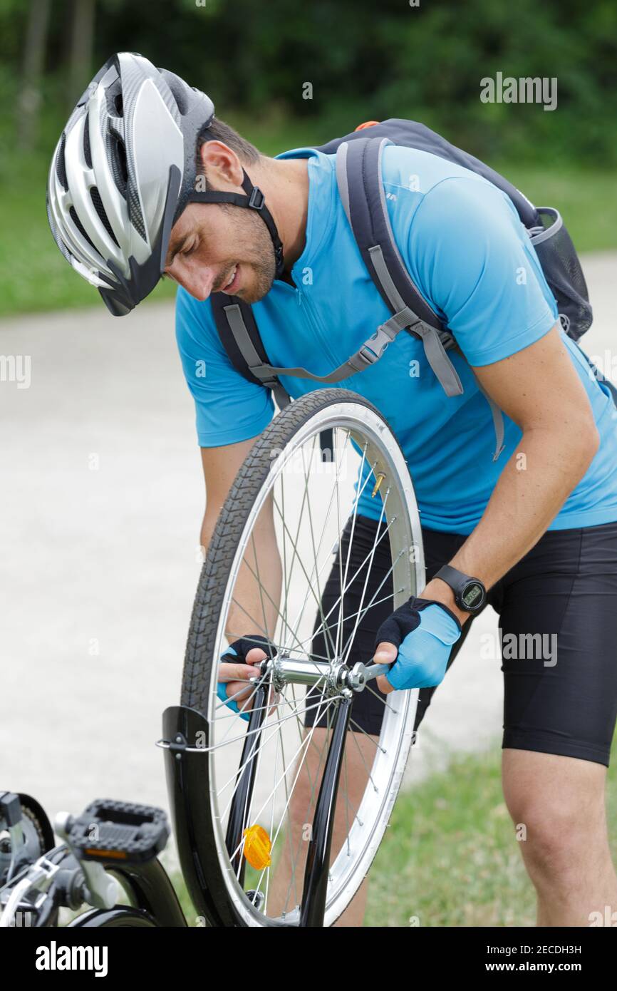 ruota di fissaggio del ciclista maschio Foto Stock