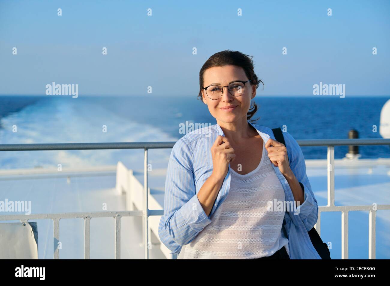Felice donna di mezza età sul ponte della nave da crociera, copy space Foto Stock