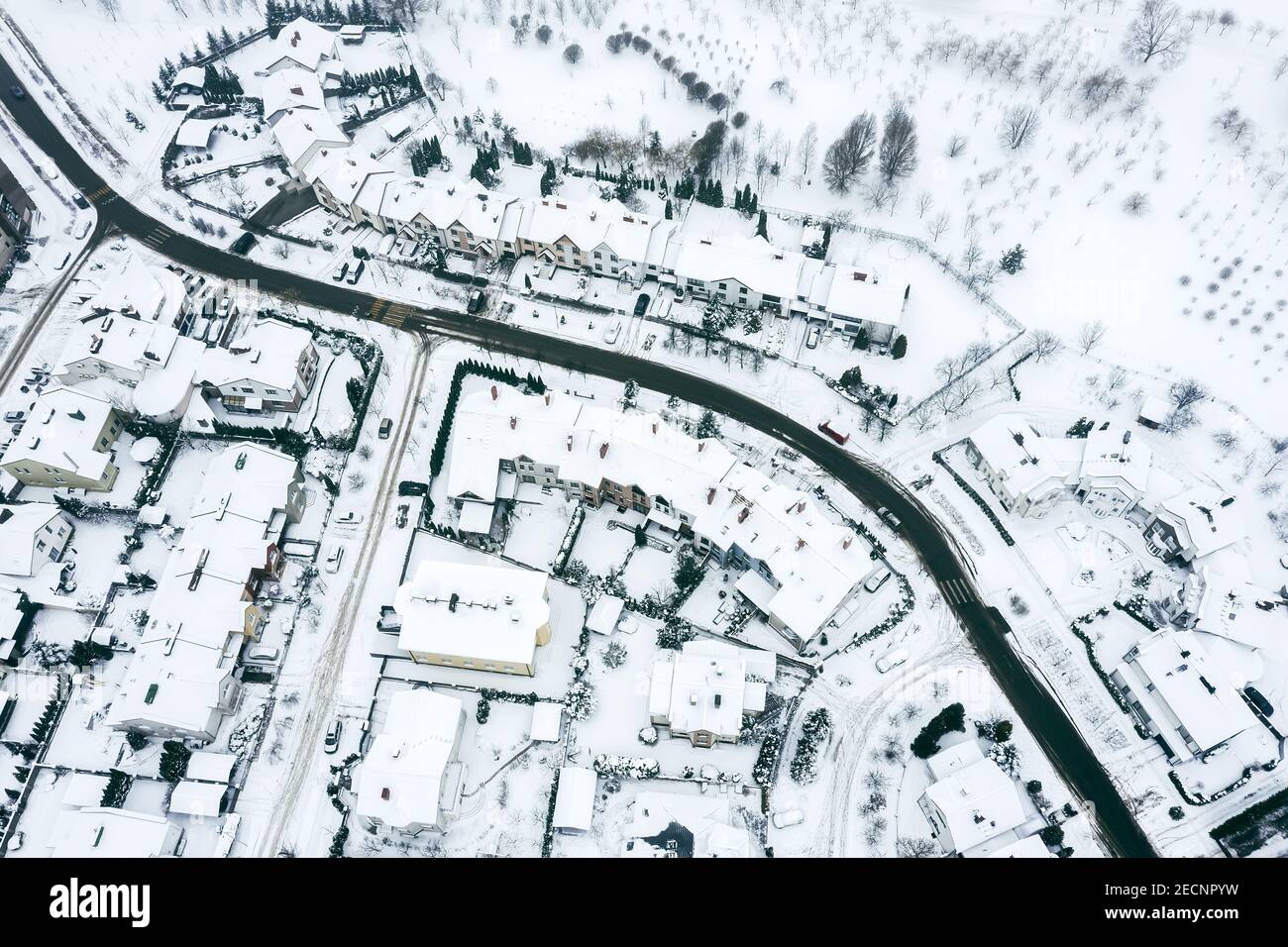 strada tortuosa circondata da case residenziali coperte di neve fresca. vista aerea drone Foto Stock