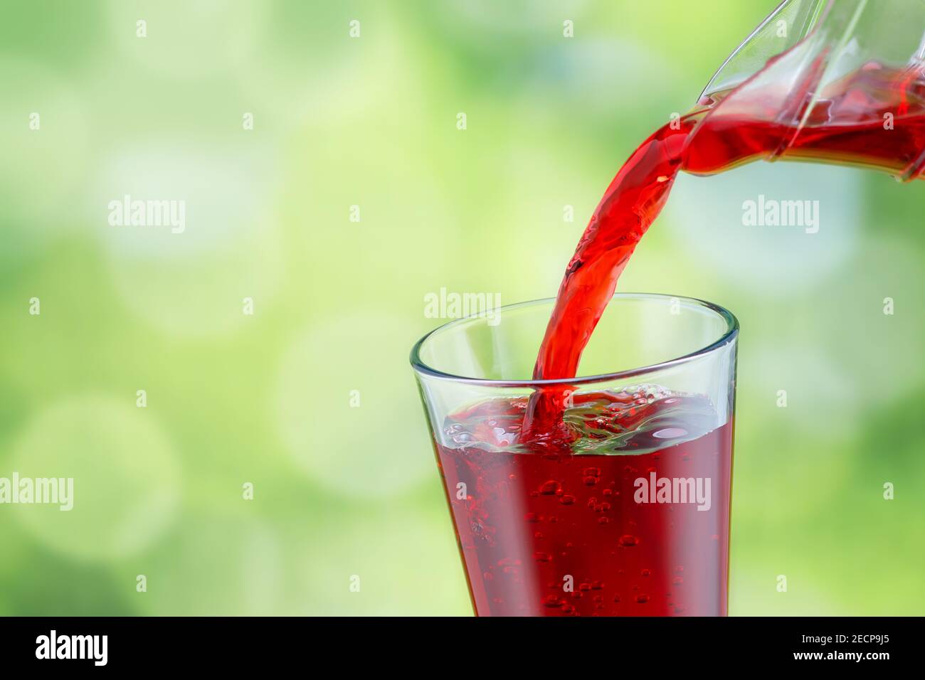 il succo viene versato in un bicchiere Foto Stock