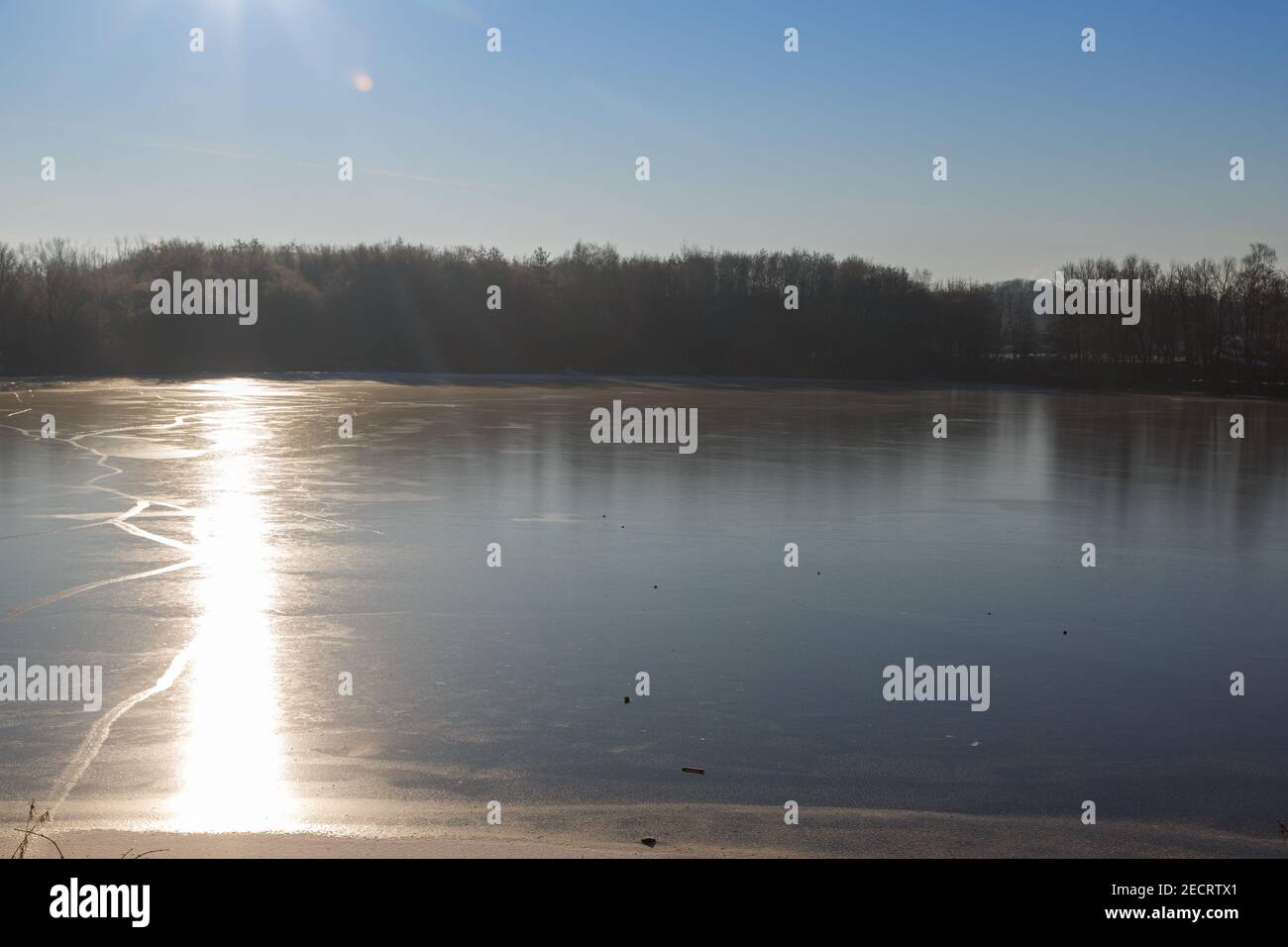 Aufgehende Sonne im Gegenlicht an der zugefrorenen Grube Fernie in Großen-Linden bei Gießen, Hessen, Deutschland im febbraio 2021 Foto Stock