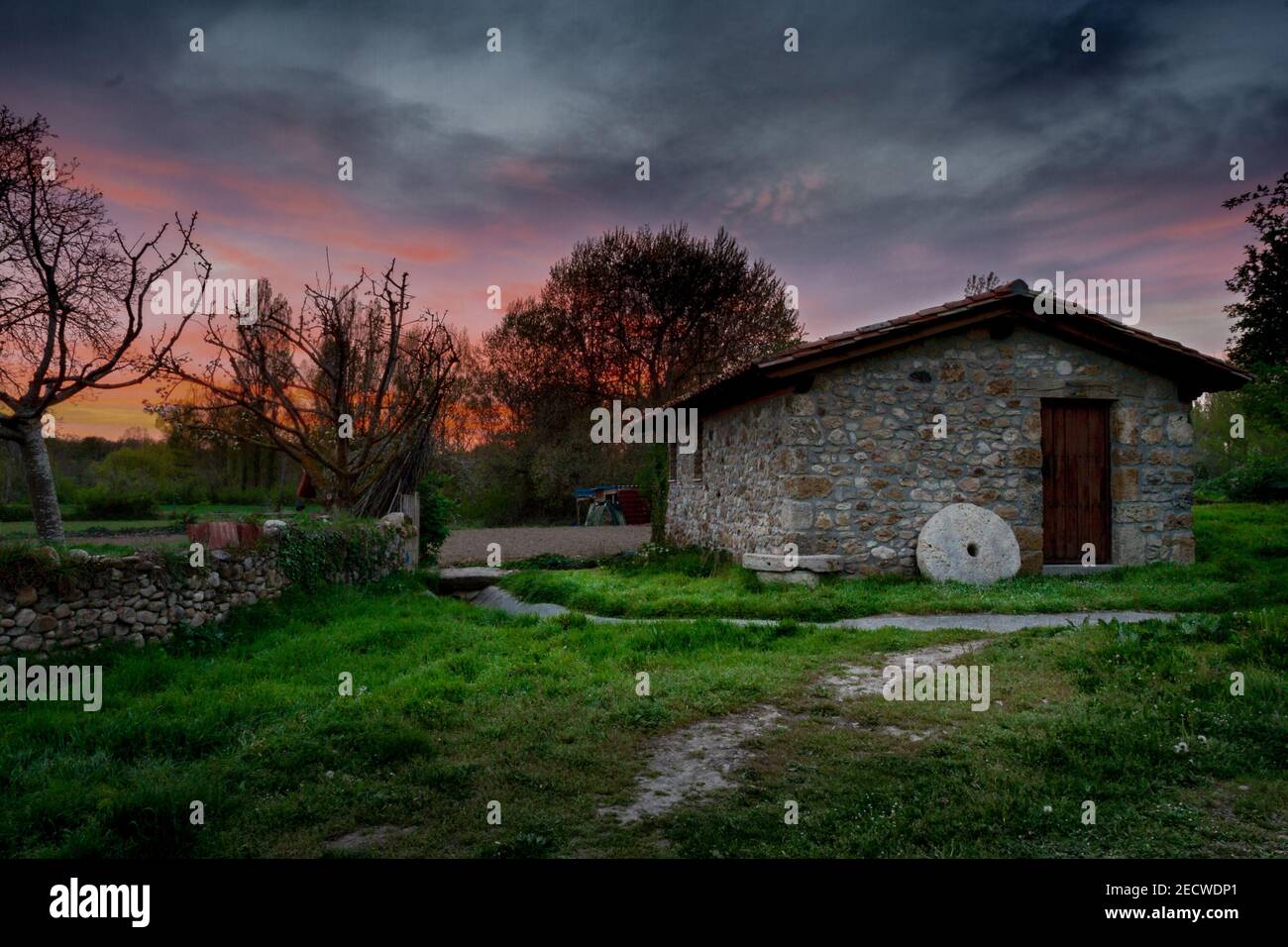 Antico mulino ad acqua restaurato nella provincia di Burgos, Torres, Spagna. Al tramonto con cielo nuvoloso Foto Stock