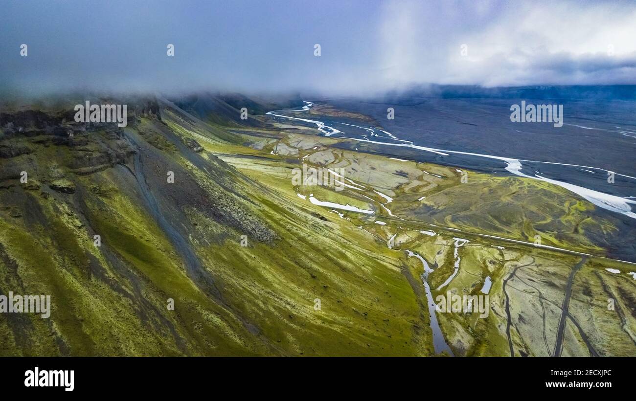 Vista mozzafiato sul paesaggio del drone di una montagna e delle pianure Insieme ad un letto di fiume nell'Islanda del Sud Foto Stock