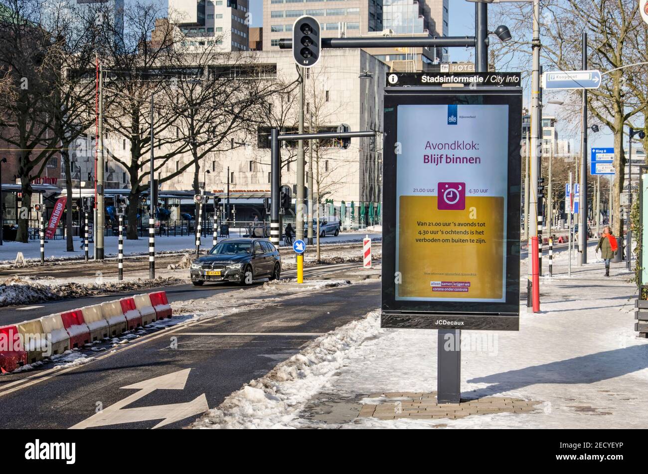 Rotterdam, Paesi Bassi, 14 febbraio 2021: Segnale elettronico che annuncia il coprifuoco come misura di covid-19 sul viale Coolsingel parzialmente innevato Foto Stock