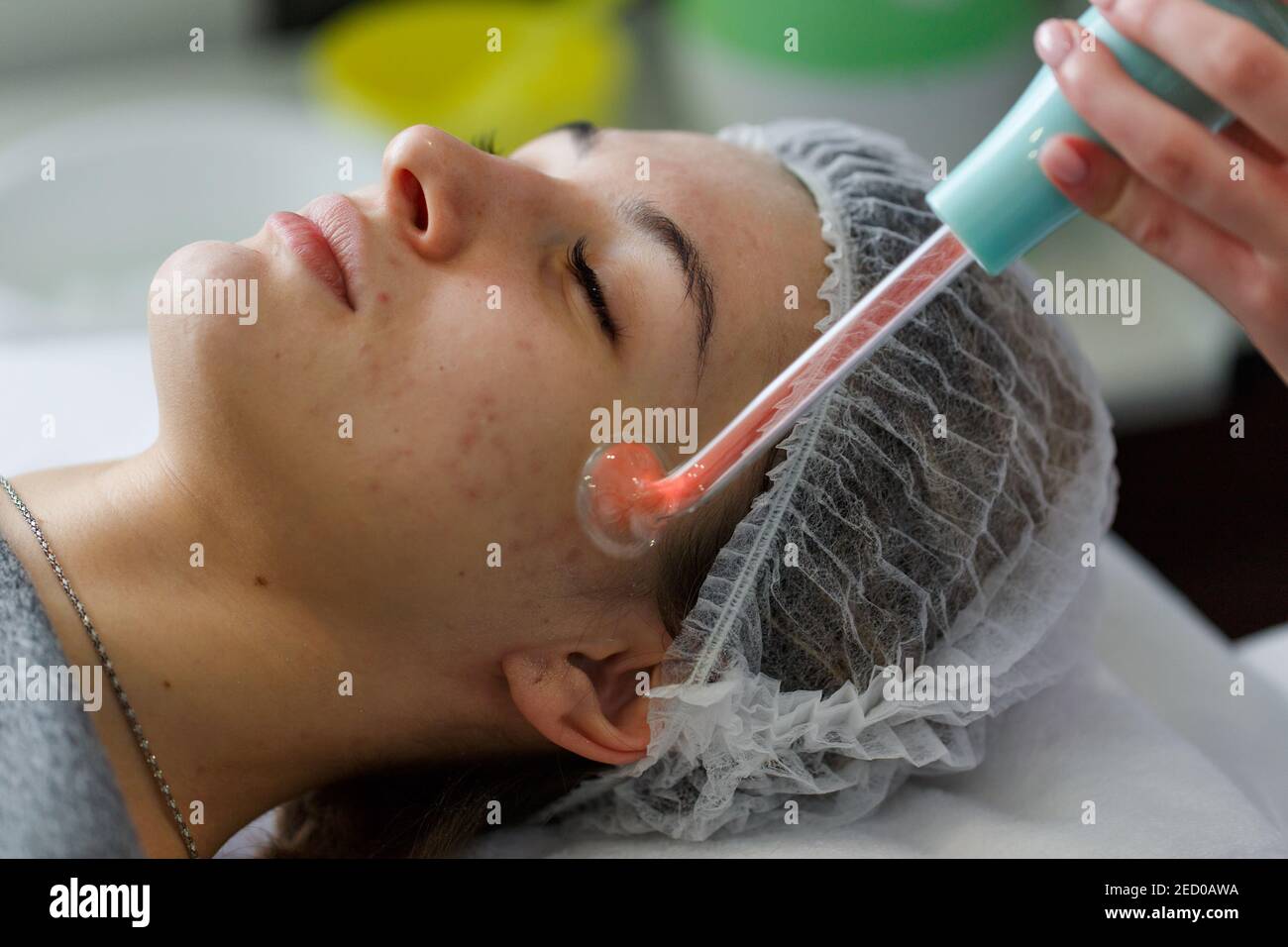 Trattamento con raggi violetti sul viso presso l'estetista. Un raggio violetto è un antico apparecchio medico utilizzato durante i primi del 20 ° secolo nella obsoleta medica Foto Stock