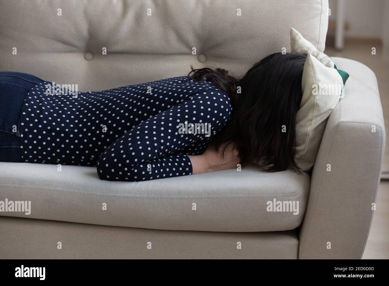 La donna millenaria seppellisce la testa nel cuscino che attraversa la crisi emotiva Foto Stock