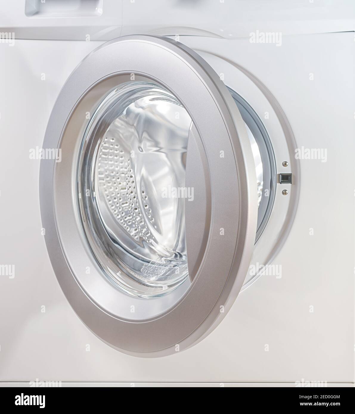Aprire lo sportello di una lavatrice da vicino con vuoto tamburo illuminato  Foto stock - Alamy