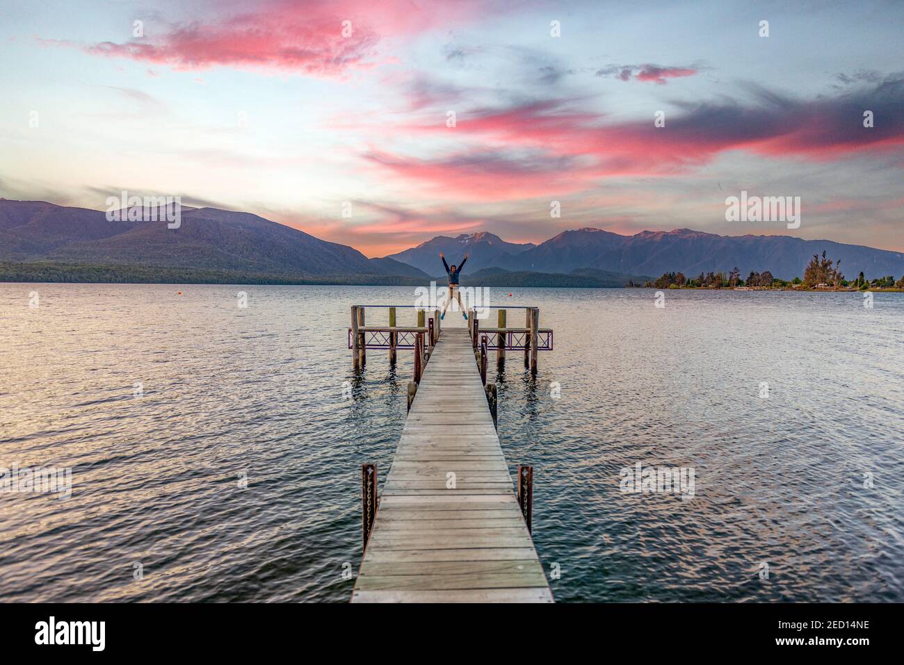 Juger man prende un skydive, molo al lago, Lago te Anau al tramonto, te Anau, Isola del Sud, Nuova Zelanda Foto Stock