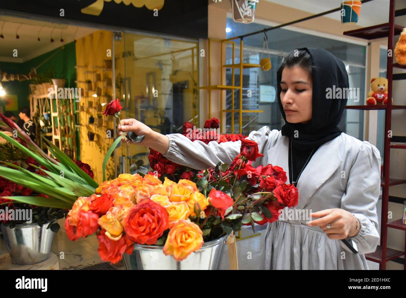Mazar i Sharif. 14 Feb 2021. Nahid Padram organizza i fiori presso il suo negozio di fiori a Mazar-i-Sharif, capitale della provincia di Balkh, Afghanistan, 13 febbraio 2021. La celebrazione del giorno di San Valentino come nuova cultura si è gradualmente mescolata alle tradizioni afghane e si è celebrata tra le giovani generazioni nella capitale afghana Kabul e alcuni altri luoghi nell'ultimo decennio. PER ANDARE CON 'Feature: Segnare San Valentino una nuova cultura che diventa radice in Afghanistan' Credit: Kawa Basharat/Xinhua/Alamy Live News Foto Stock