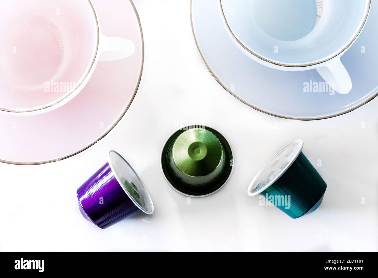 Vista dall'alto della raccolta delle cialde di caffè poste vicino a vuoto tazza e piattino in ceramica su sfondo bianco Foto Stock