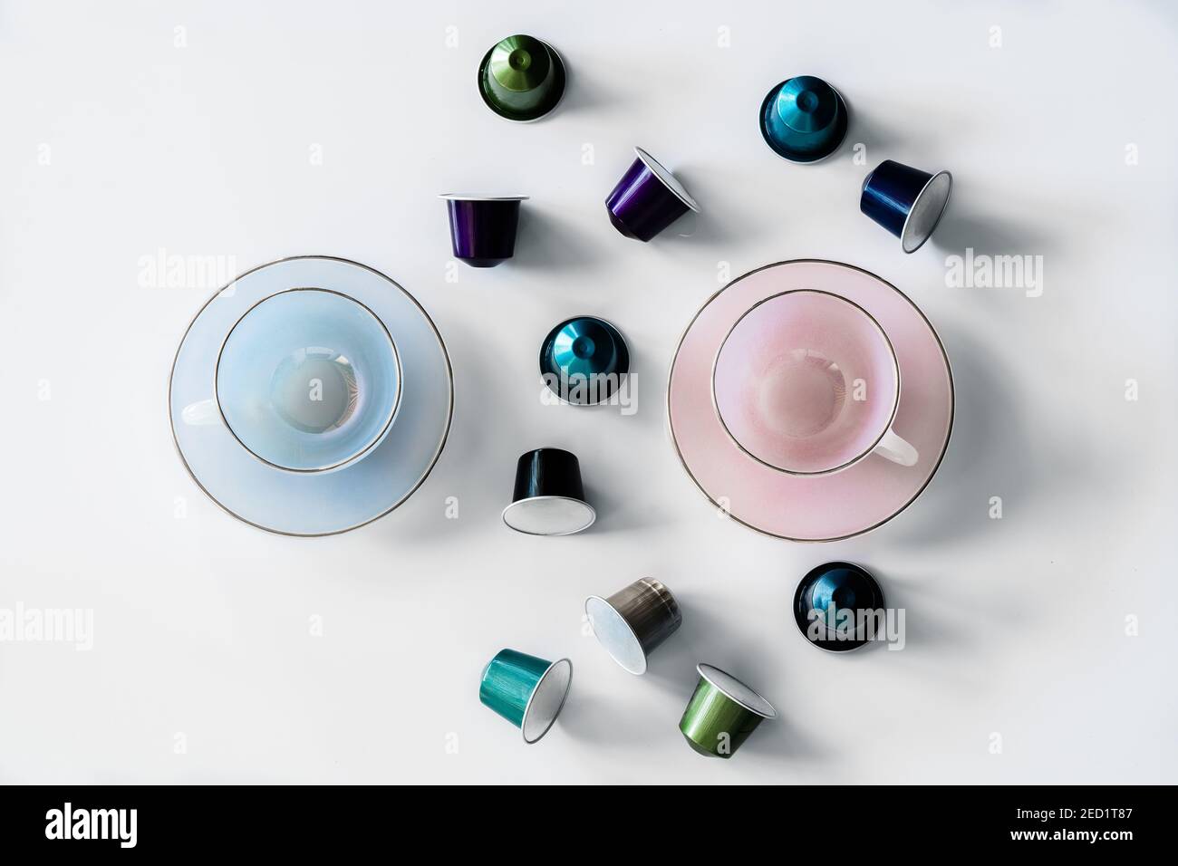 Vista dall'alto della raccolta delle cialde di caffè poste vicino a vuoto tazza e piattino in ceramica su sfondo bianco Foto Stock