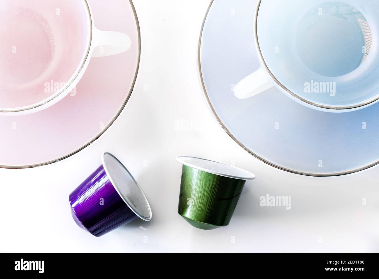 Vista dall'alto della raccolta delle cialde di caffè poste vicino a vuoto tazza e piattino in ceramica su sfondo bianco Foto Stock