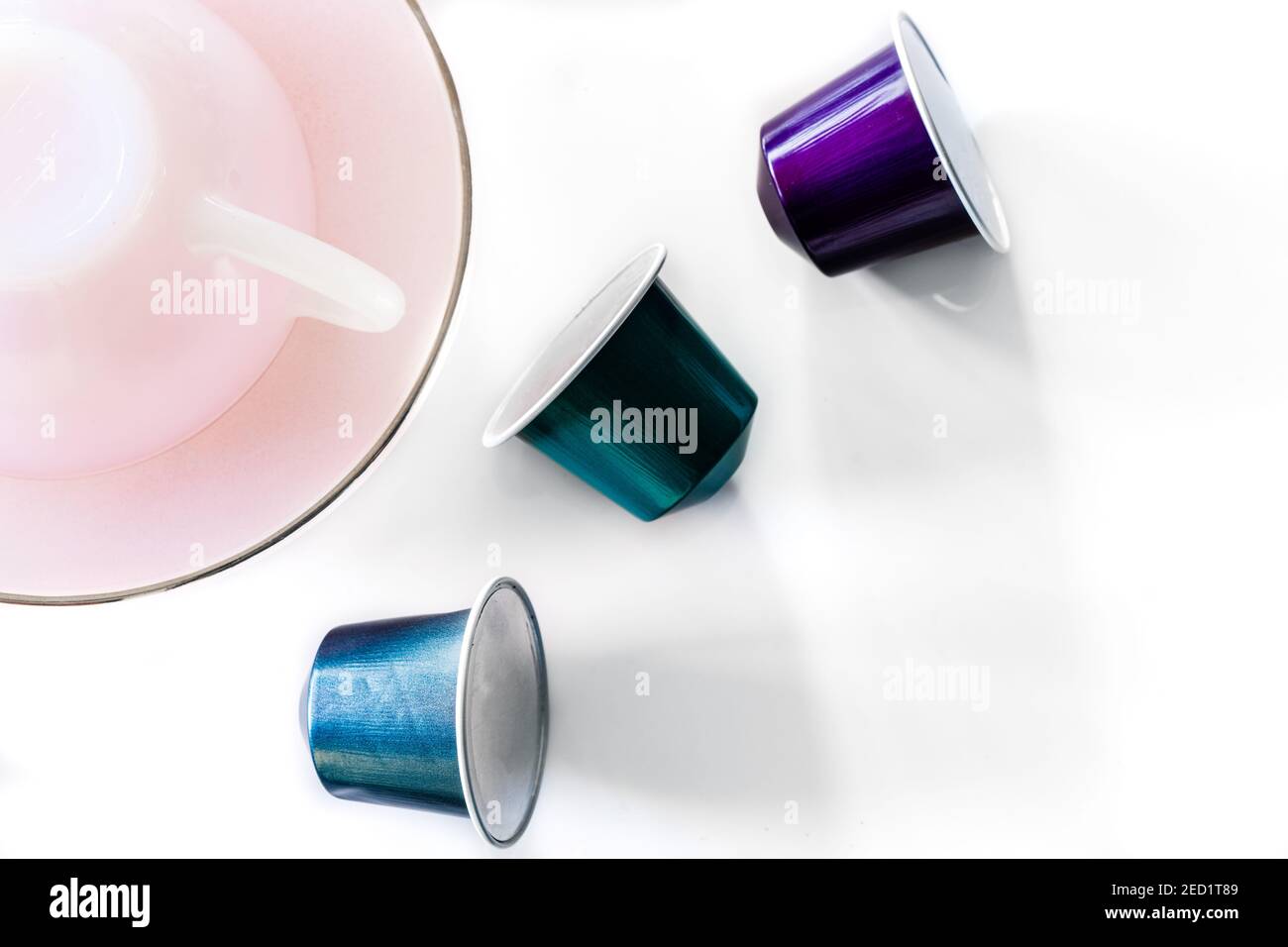 Vista dall'alto della raccolta delle cialde di caffè poste vicino a vuoto tazza e piattino in ceramica su sfondo bianco Foto Stock