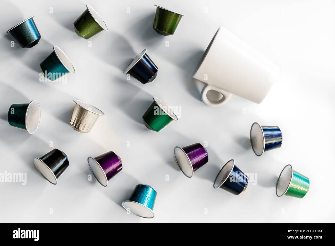 Vista dall'alto della raccolta delle cialde di caffè poste vicino a vuoto tazza e piattino in ceramica su sfondo bianco Foto Stock