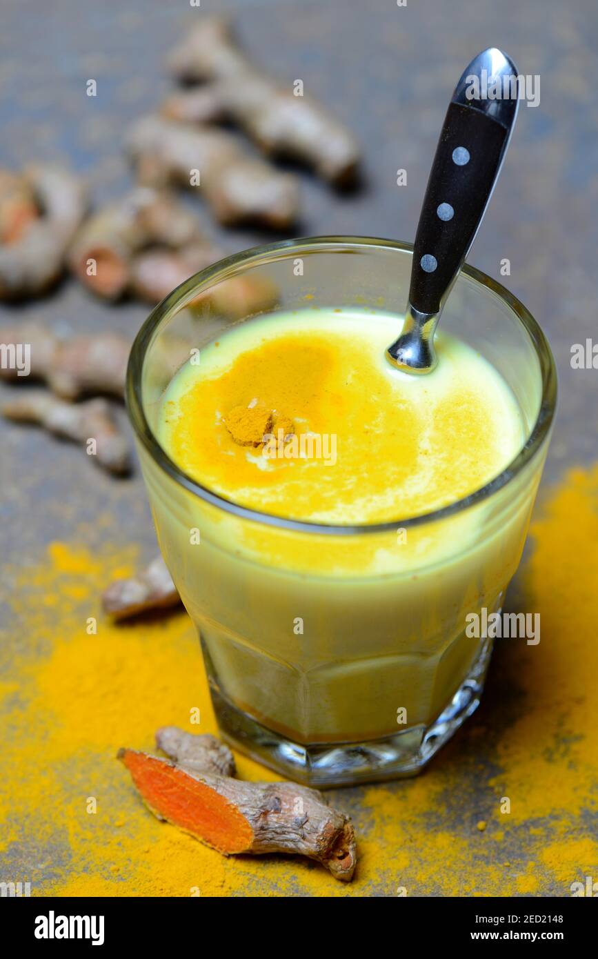 Latte curcuma in vetro, radice Foto Stock