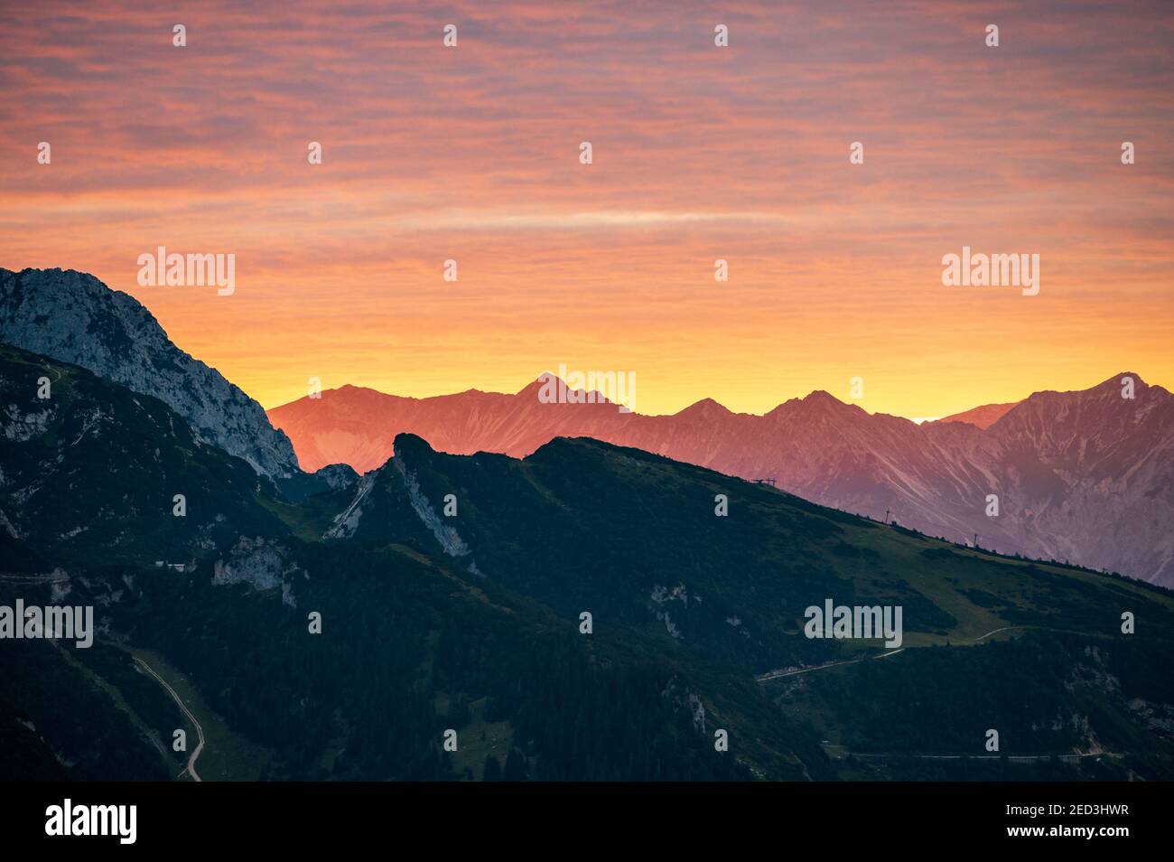 Un forte bagliore di alp prima del tramonto sulle alpi appare come le montagne sono sul fuoco Foto Stock