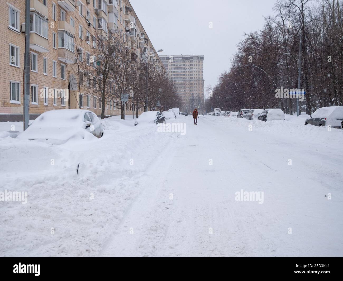 Mosca. Russia. 13 febbraio 2021. Le auto parcheggiate lungo la strada in una giornata invernale sono coperte da uno spesso strato di neve dopo una pesante nevicata. Foto Stock