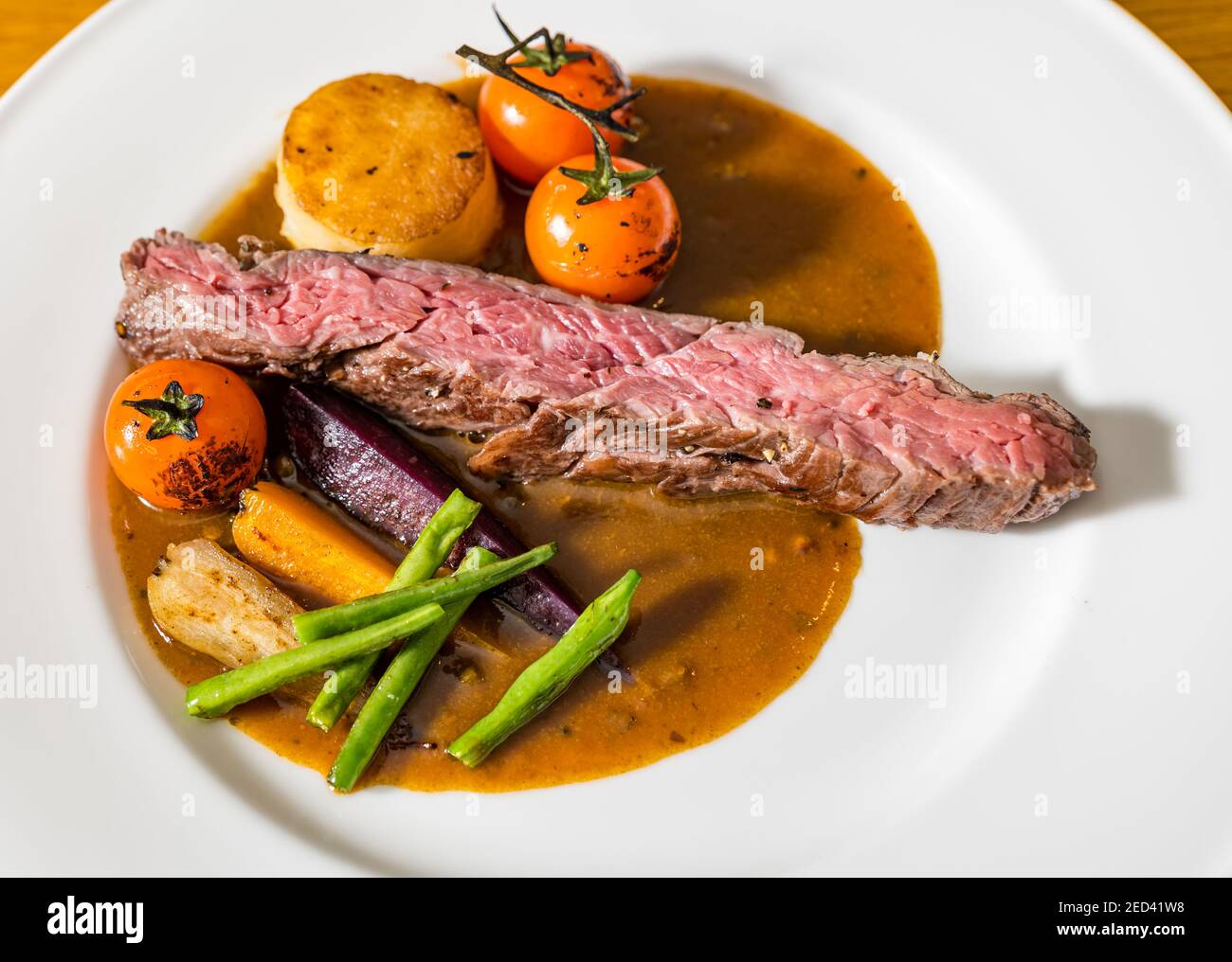 Piatto da pranzo raffinato: Bistecca di bavette, carote, fagioli, patate fondenti e salsa di pepe-corn dallo chef Paul Wedgwood, Scozia, Regno Unito Foto Stock