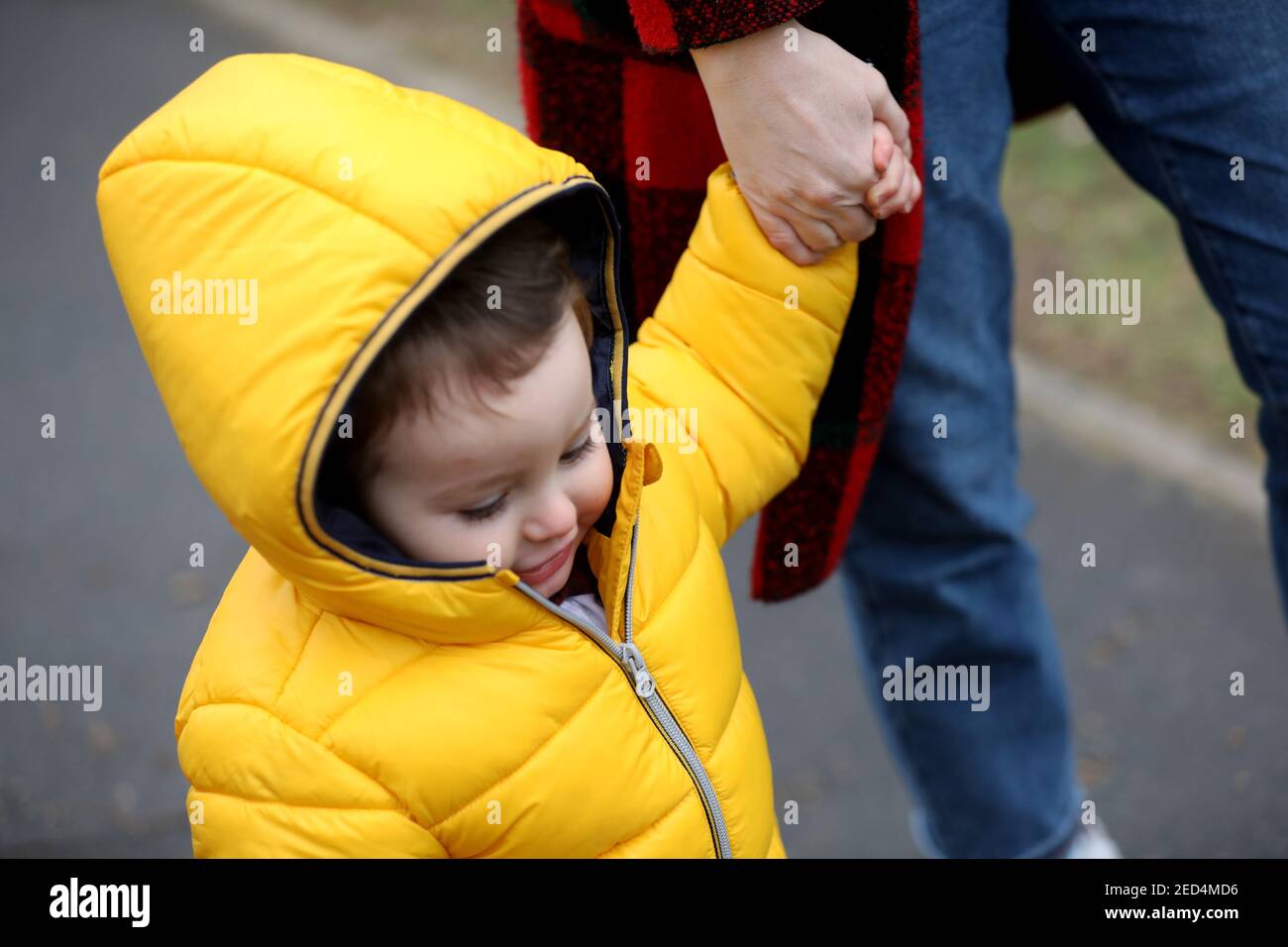 Un bambino di un anno ha ritratto che osserva astuto e appendere fuori con la sua mamma a Chichester, Sussex occidentale, Regno Unito. Foto Stock